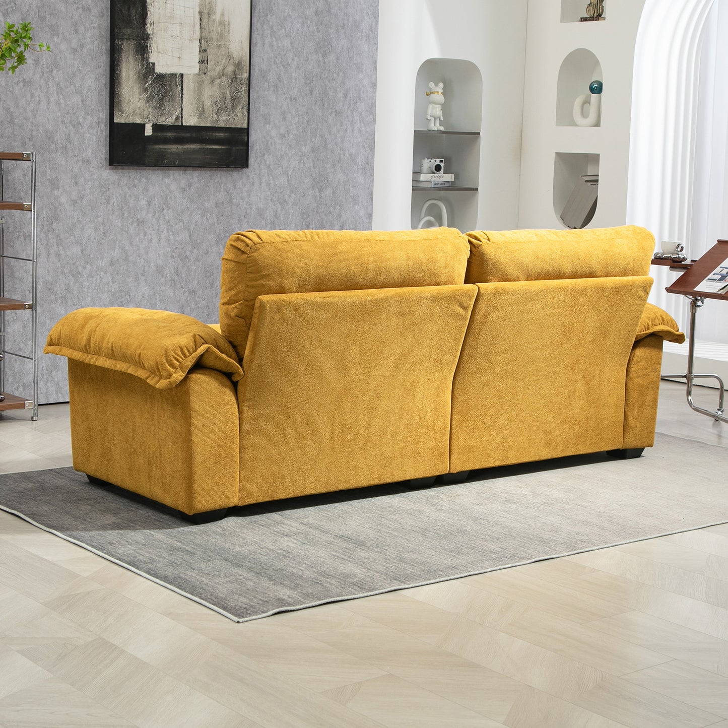 Plush mustard yellow velvet sofa with rolled armrests on a gray rug