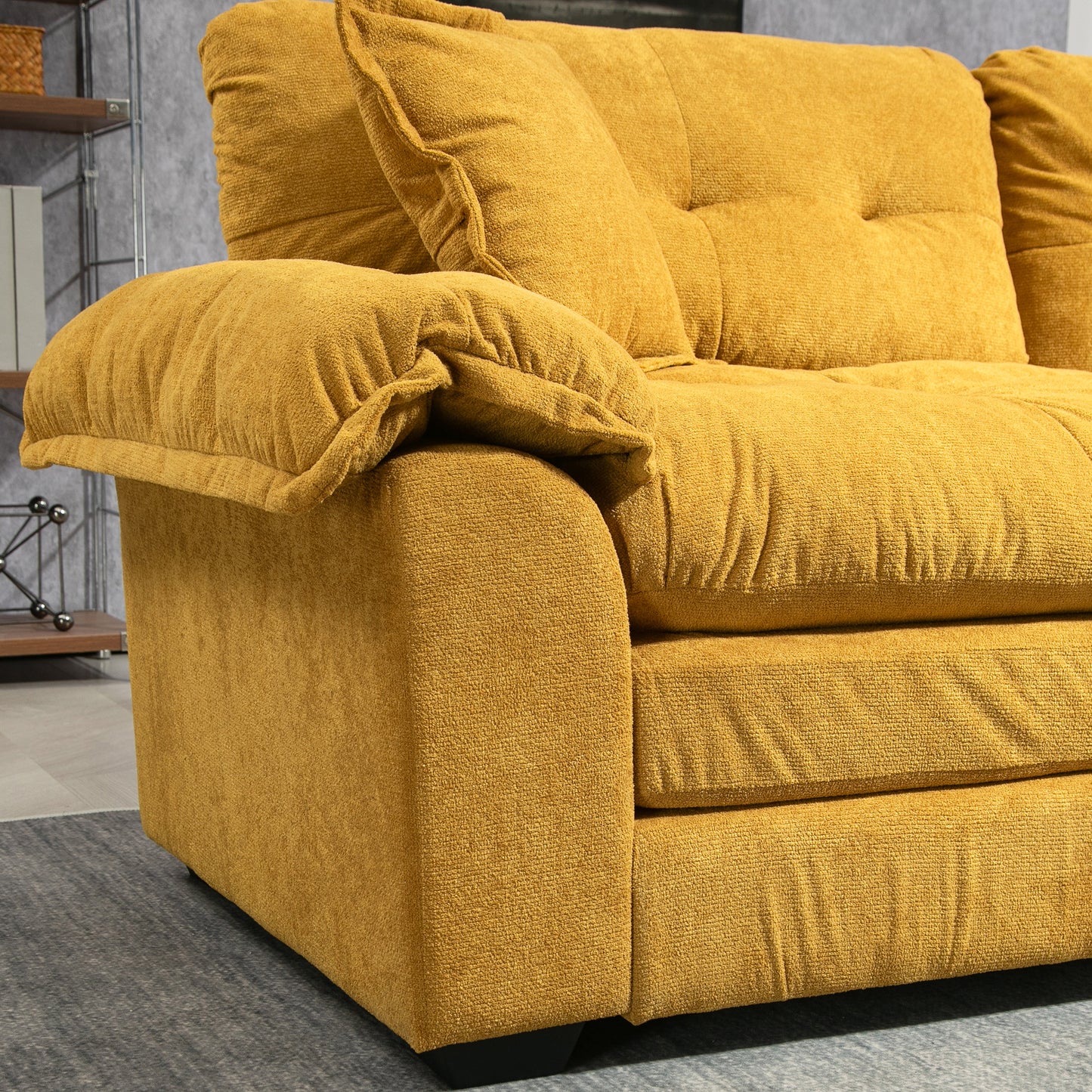 Plush mustard yellow fabric sofa with tufted back cushions and a wide armrest