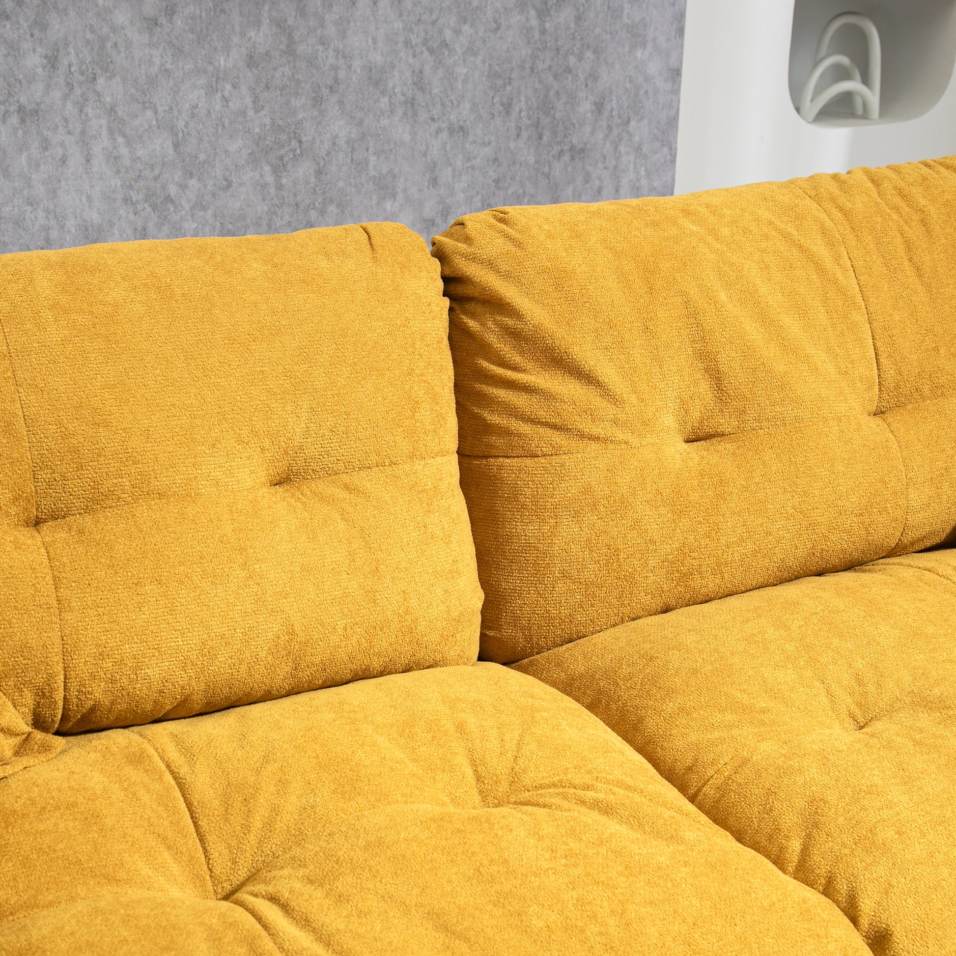 Closeup of textured mustard yellow sofa cushions with button tufting
