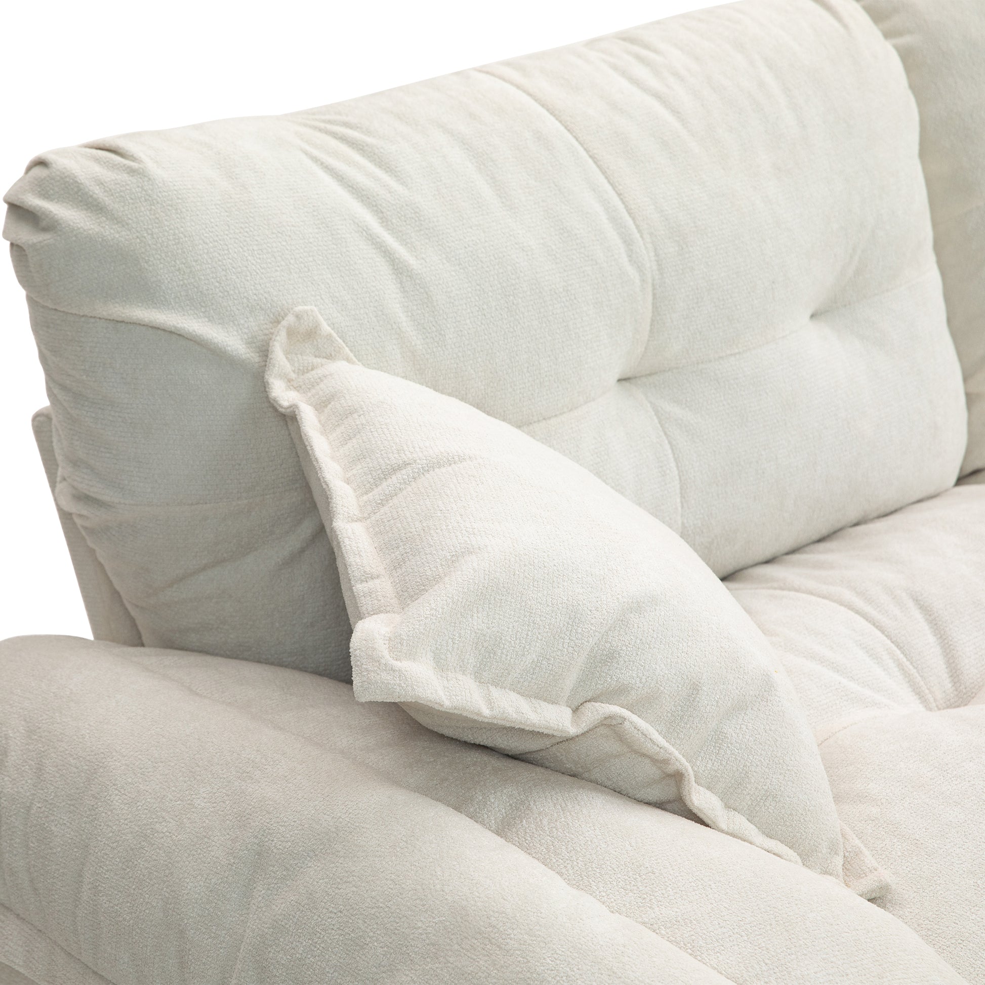 Plush cream sofa with tufted back cushions and a loose throw pillow for comfort