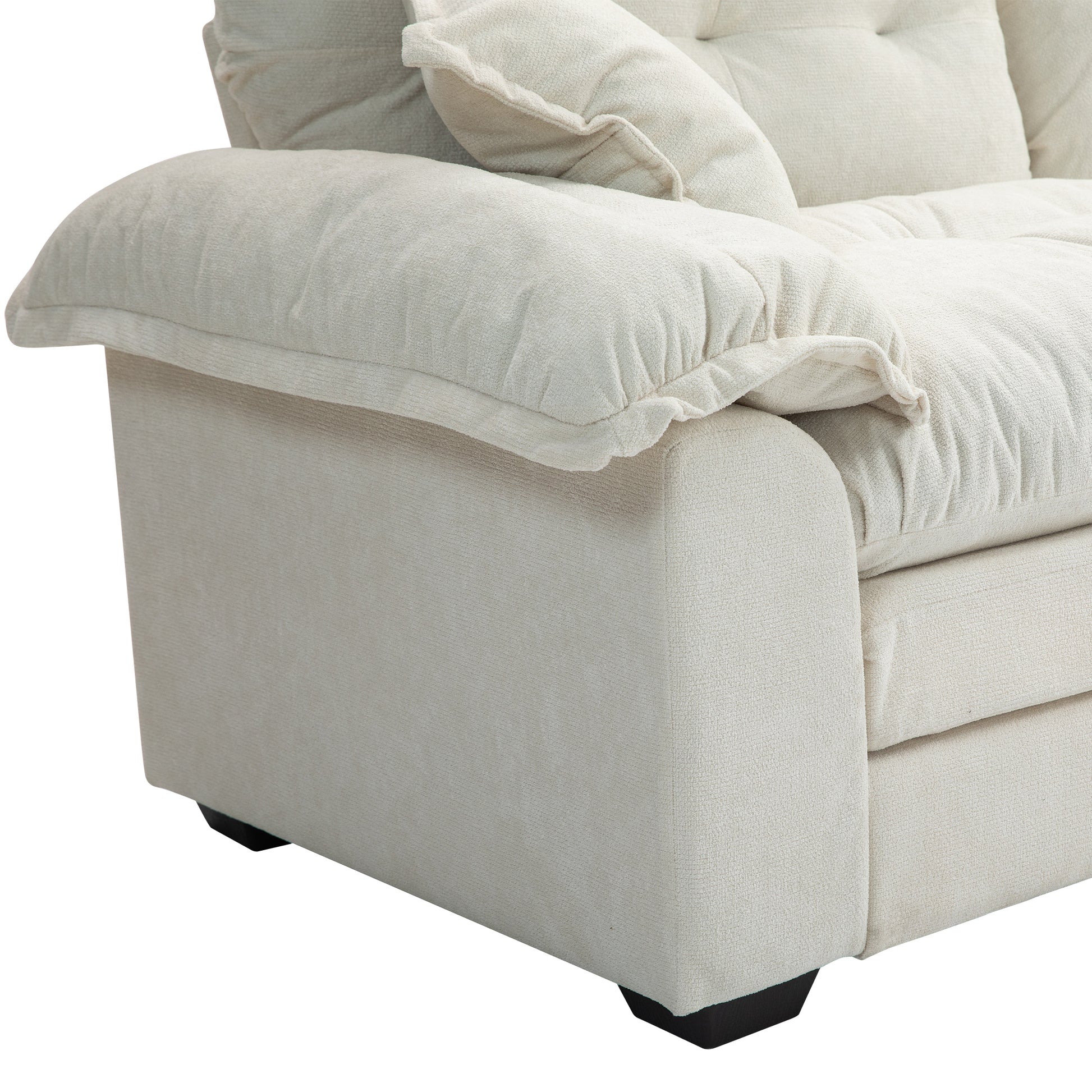 Closeup of a cream textured fabric sofa arm with plush cushions
