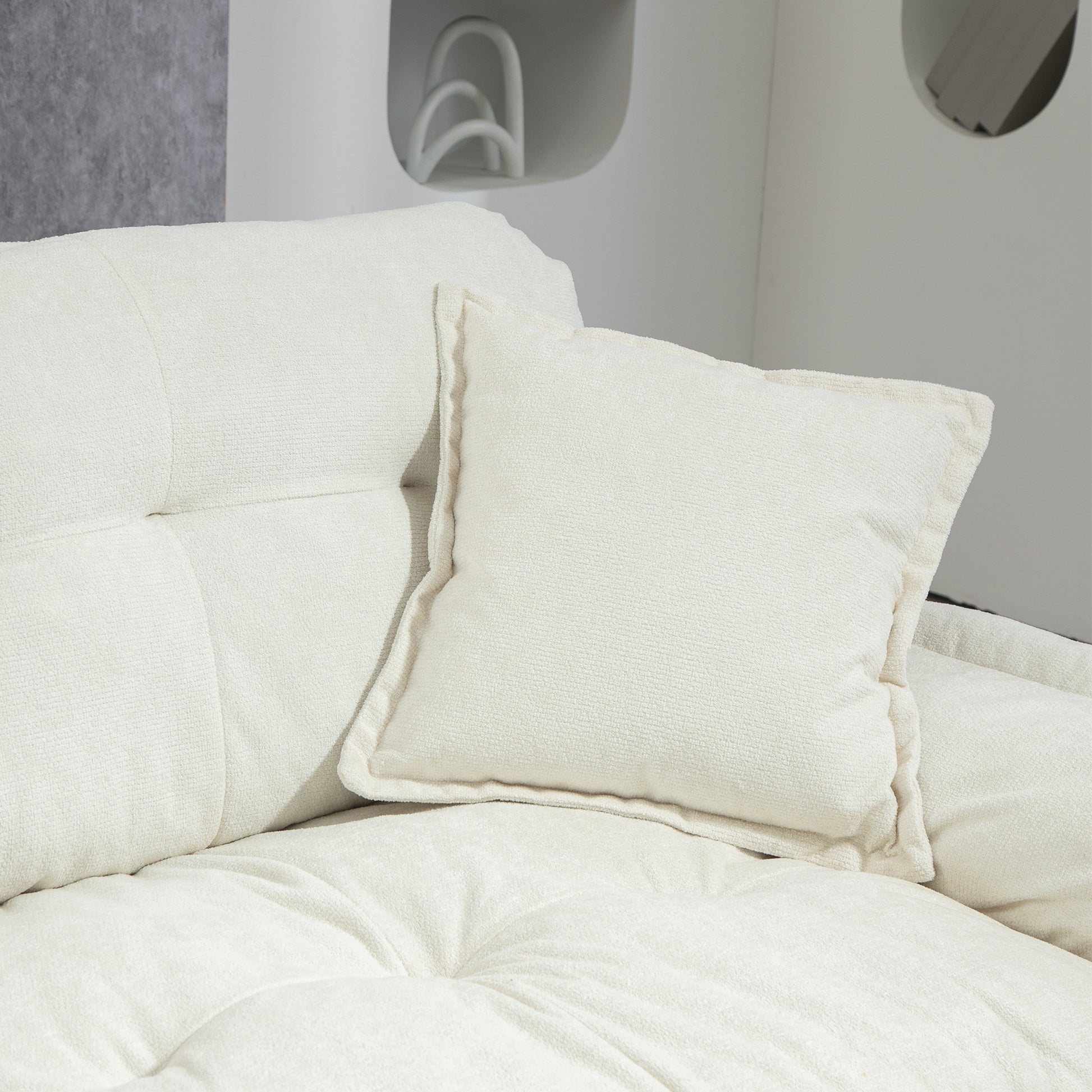 Textured cream square pillow on tufted sofa perfect for living room decor