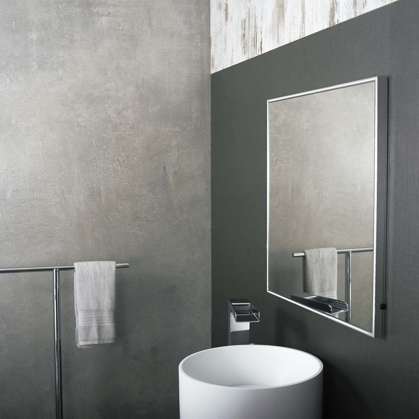 Modern bathroom with a white basin and chrome faucet featuring a framed mirror