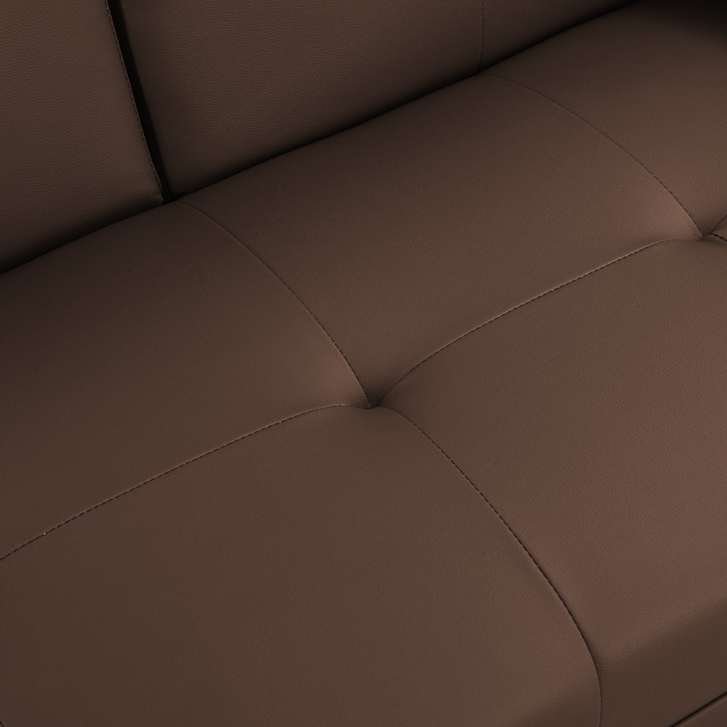 Closeup of tufted brown leather sofa cushion with detailed stitching adding modern elegance
