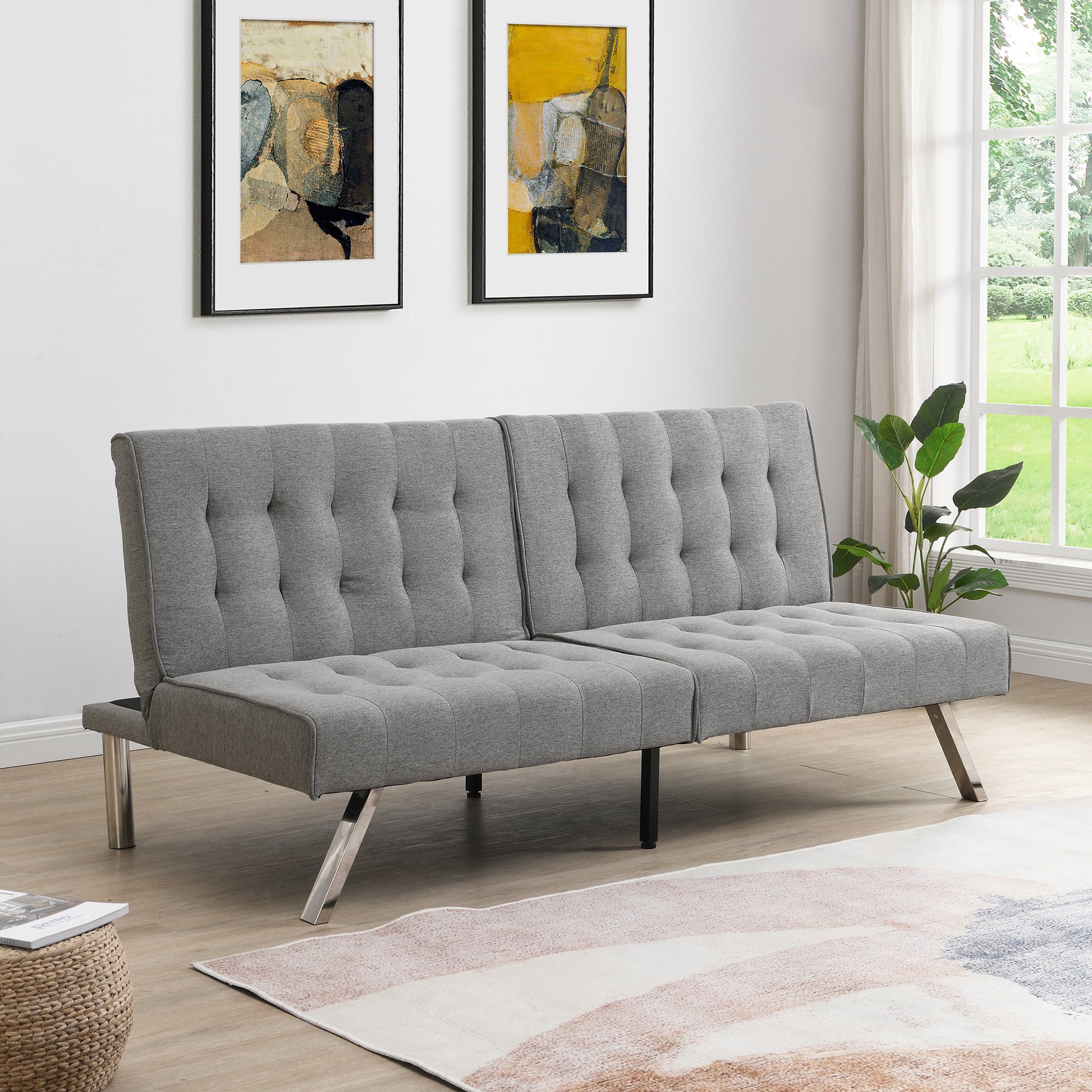 Gray tufted futon sofa with metal legs in a modern living room setting