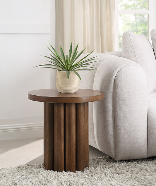Round walnut side table with fluted pedestal base and plant on top