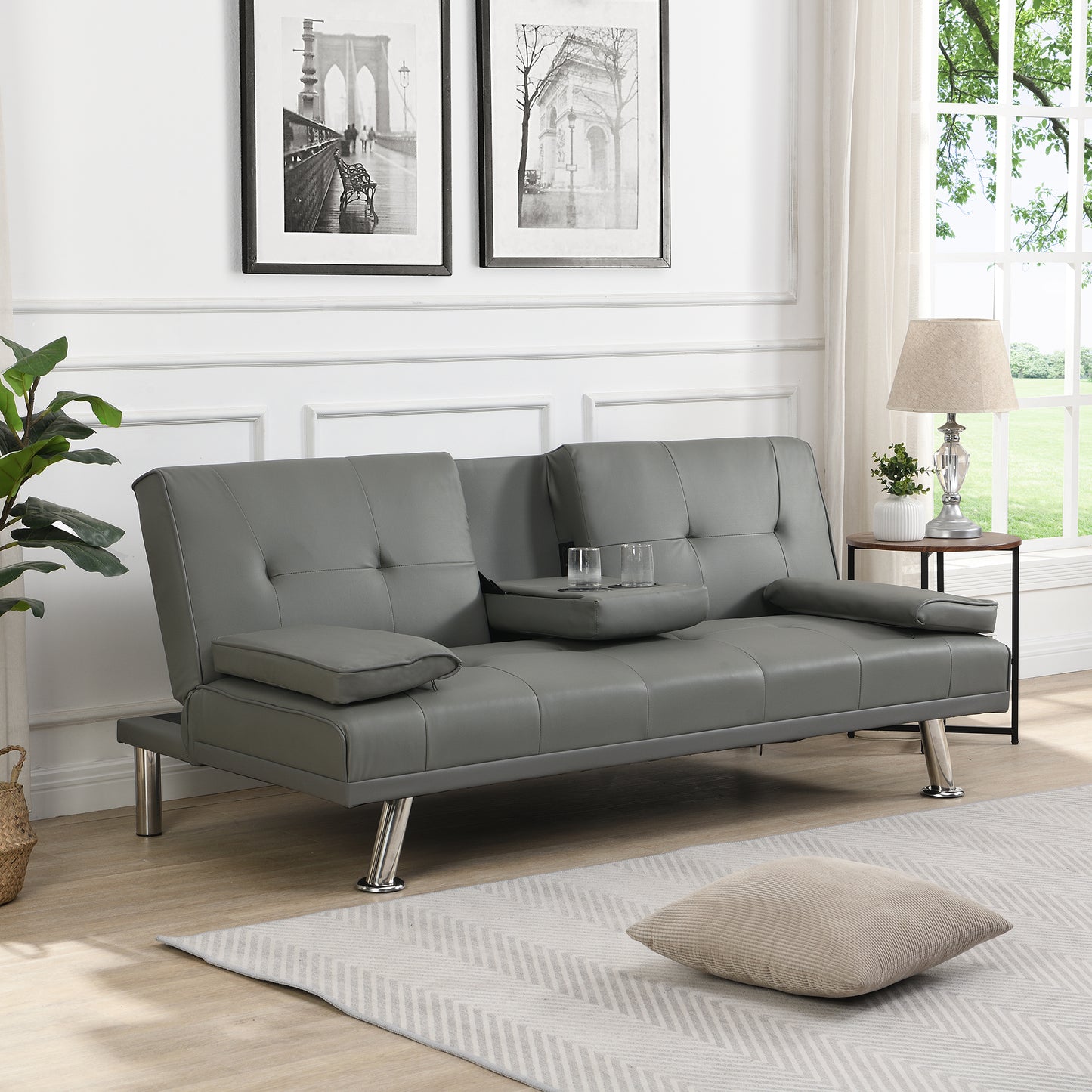 Gray faux leather sofa bed with tufted cushions and builtin cup holders