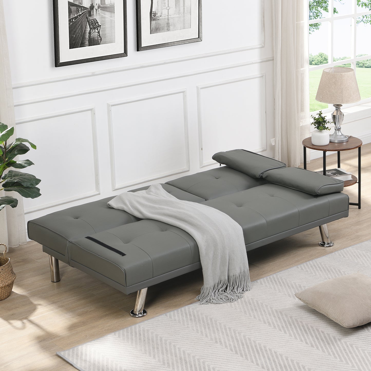 Grey faux leather futon sofa with tufted detailing and chrome legs perfect for small spaces