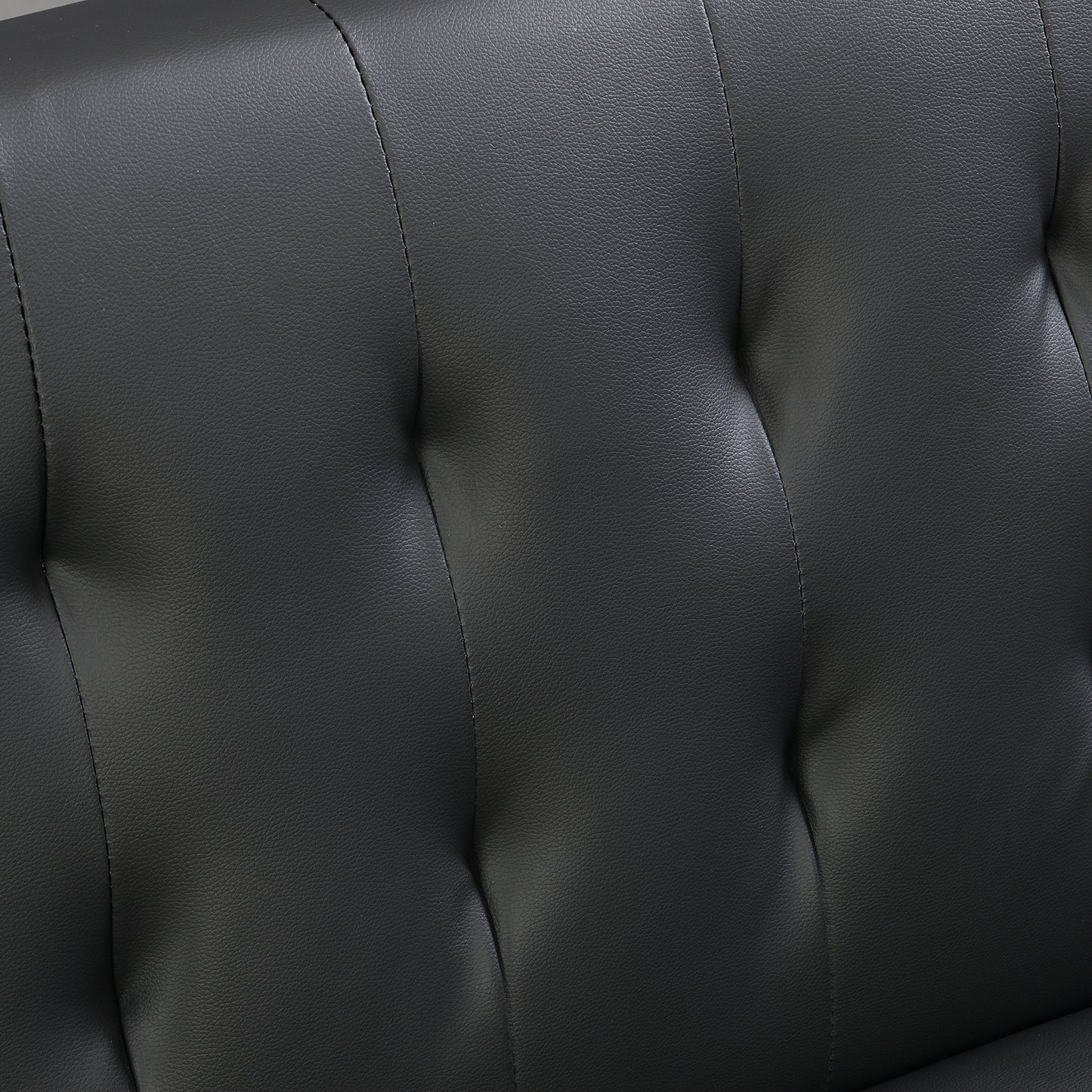 Closeup of textured black faux leather upholstery with diamond tufting detail