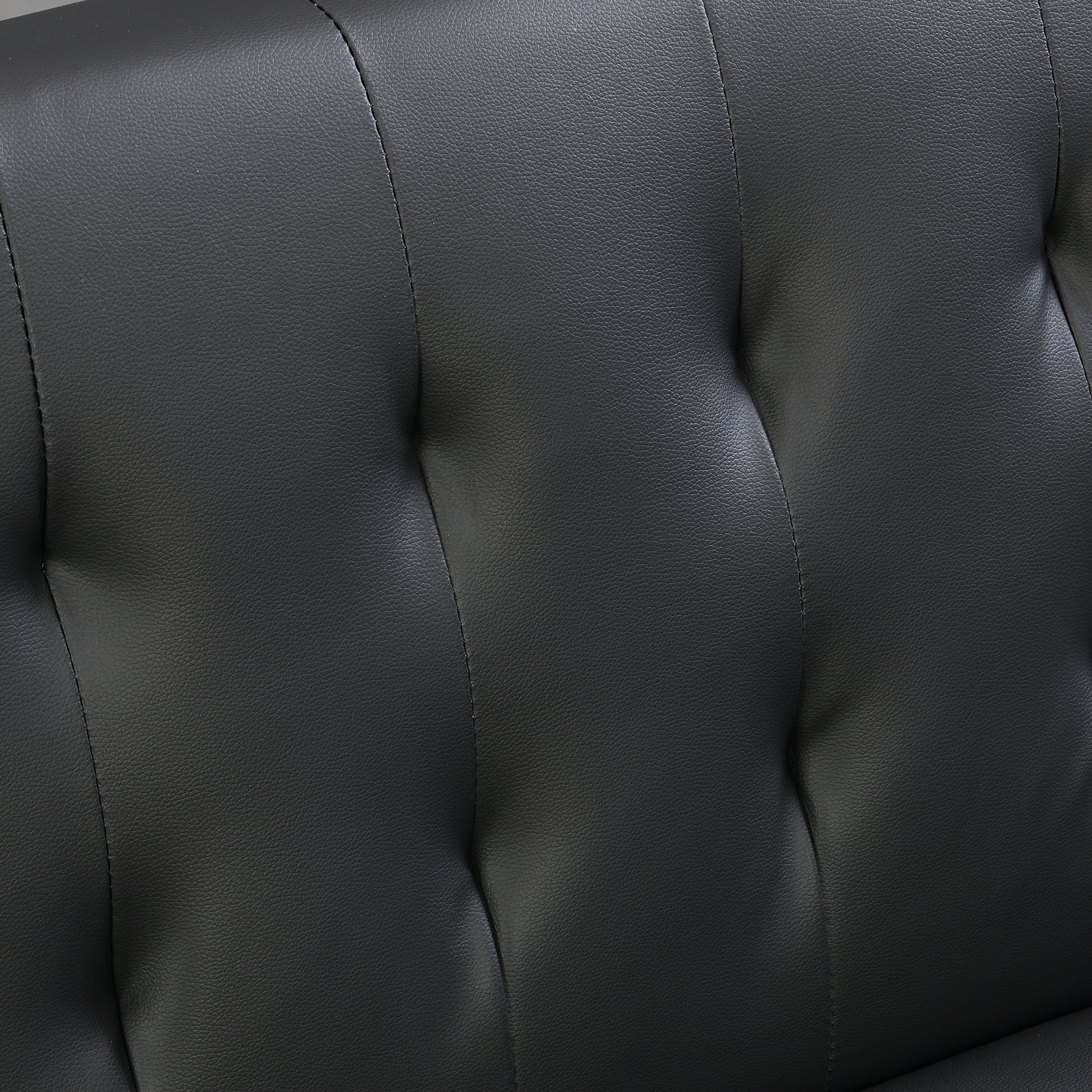 Closeup of textured black faux leather upholstery with diamond tufting detail