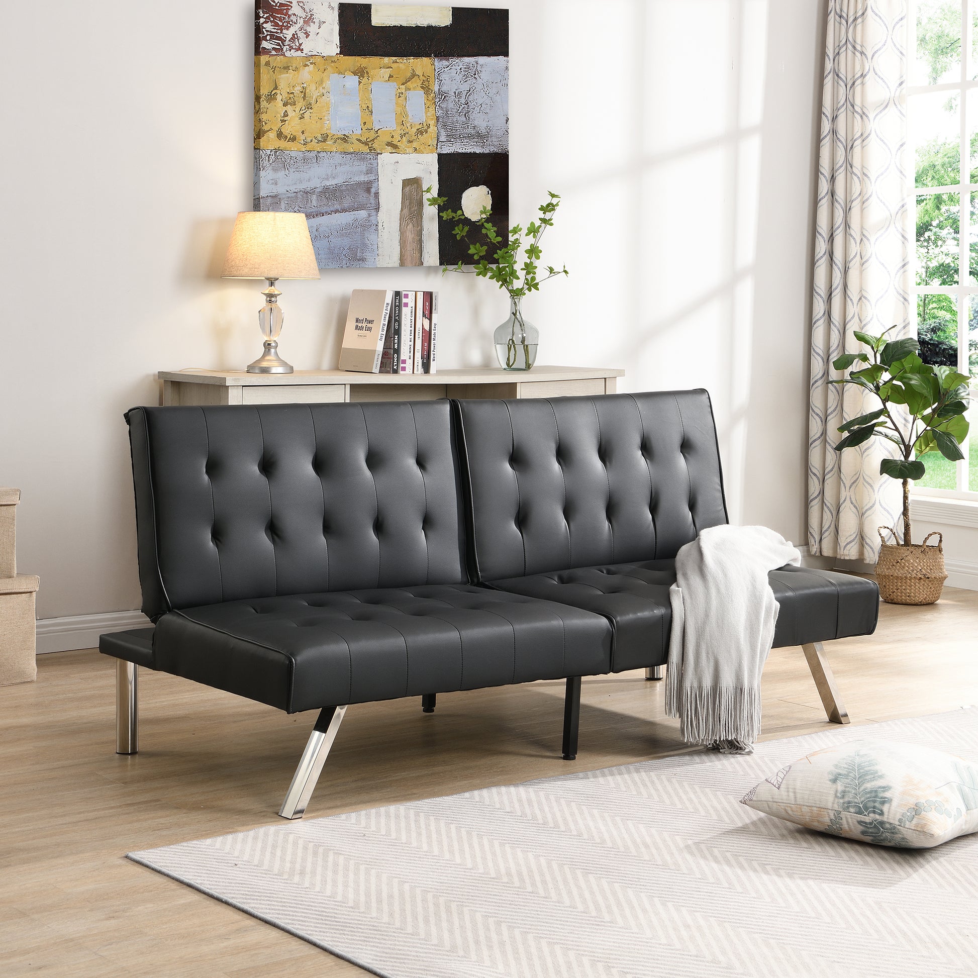 Black faux leather tufted futon sofa with chrome legs perfect for small spaces
