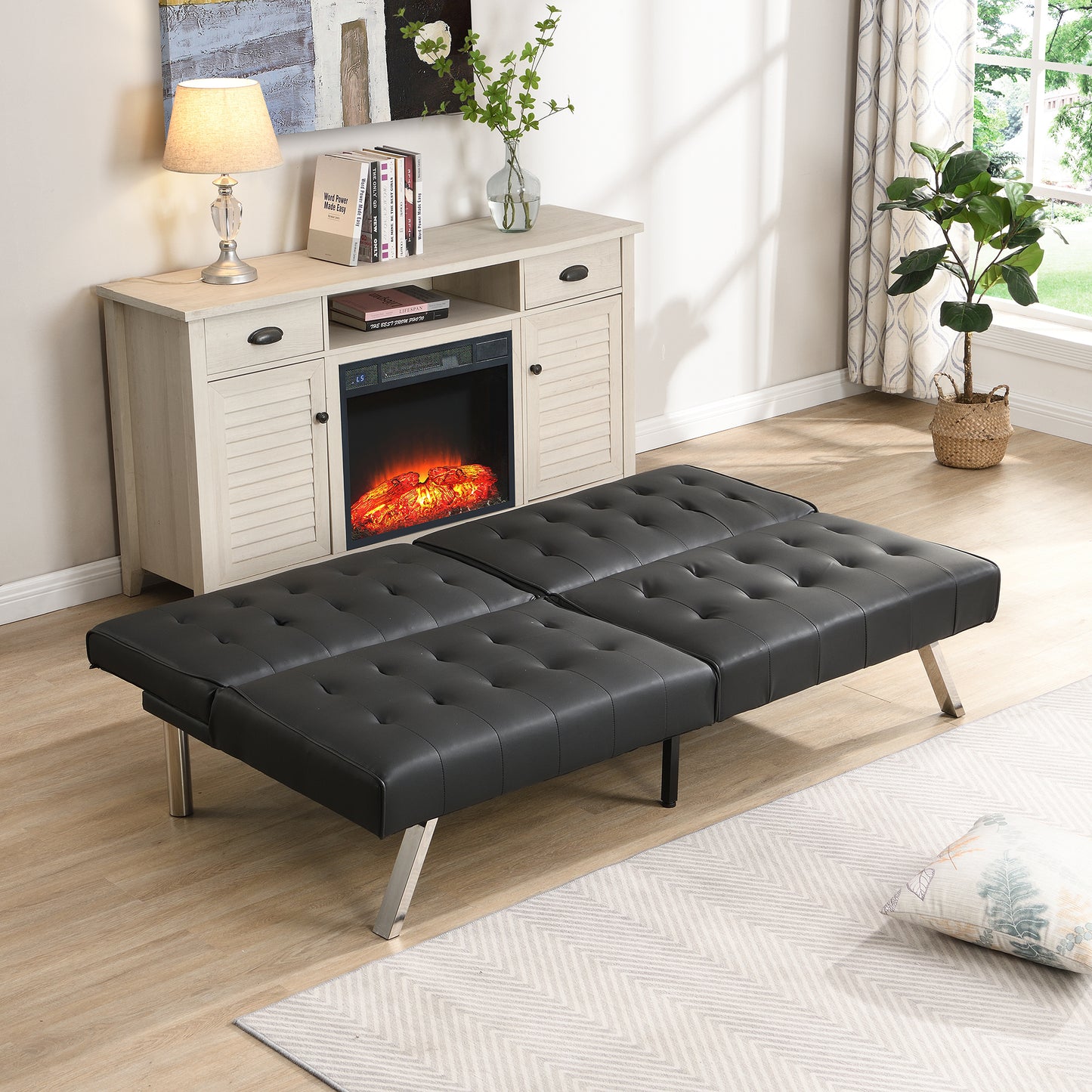 Black tufted faux leather futon sofa bed with silver legs in a living room