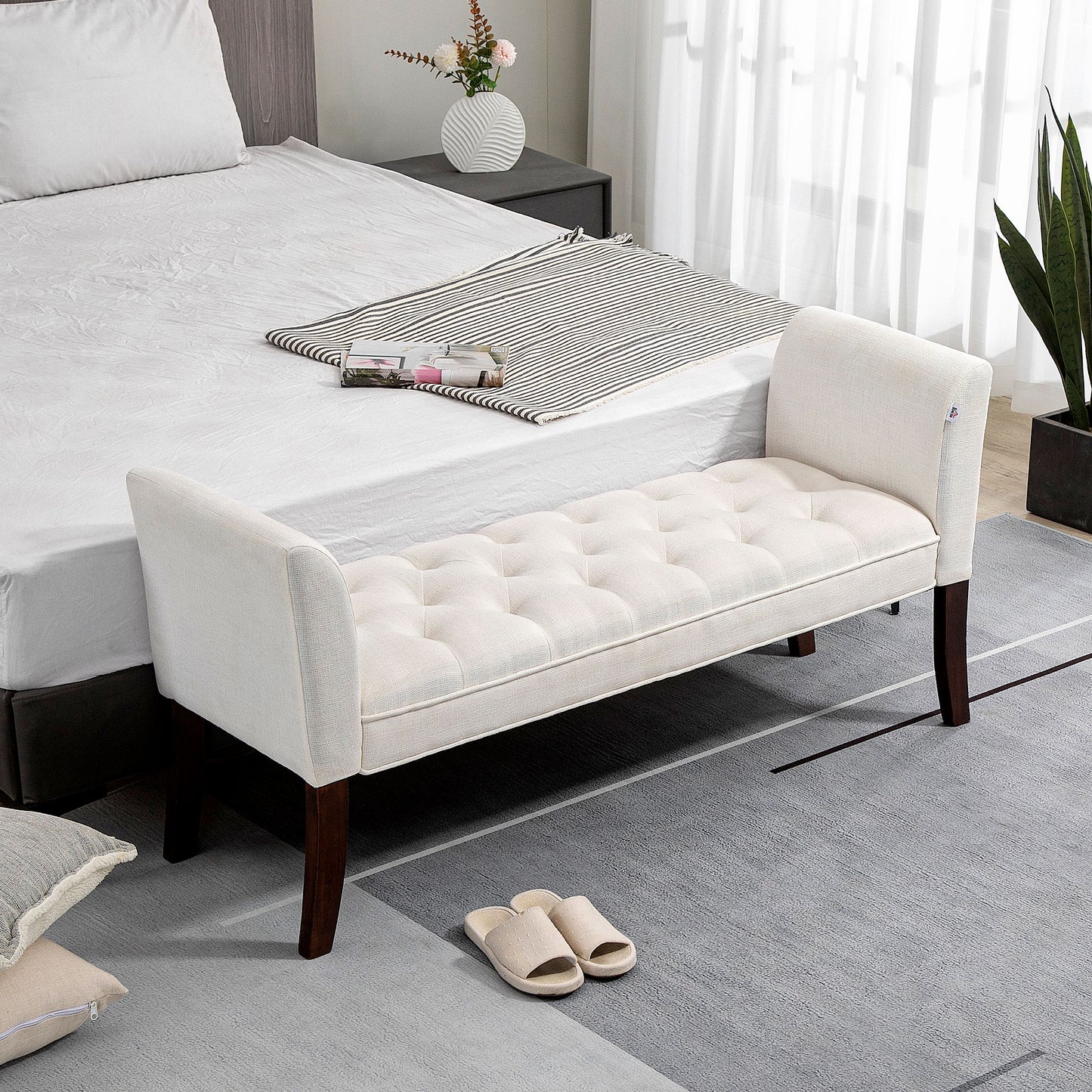 Cream linen tufted bench with dark wood legs and rolled arms