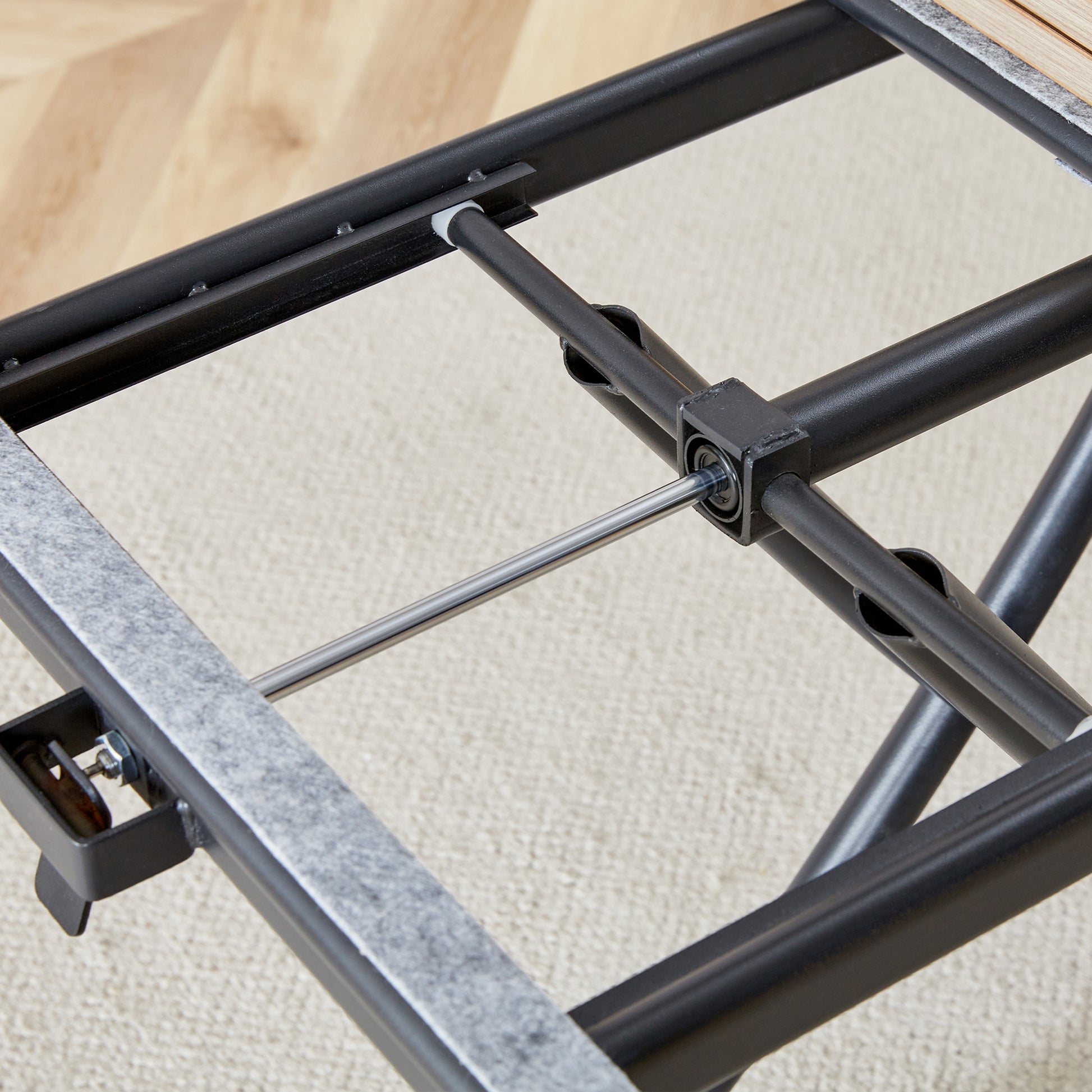Closeup of a black metal folding chair frame with metal hinges