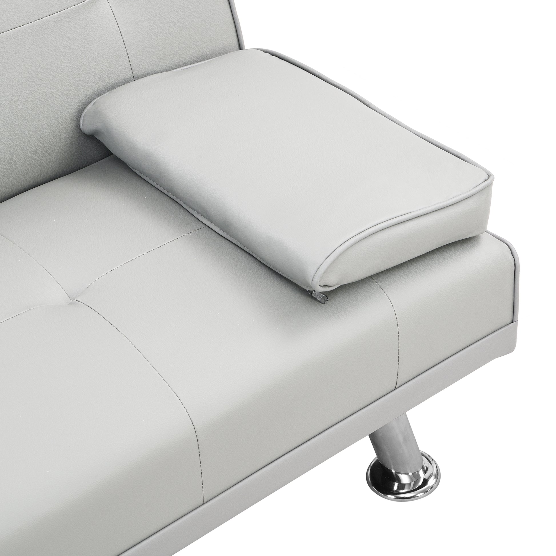 Closeup of a light grey faux leather sofa armrest with tufted stitching and a chrome leg