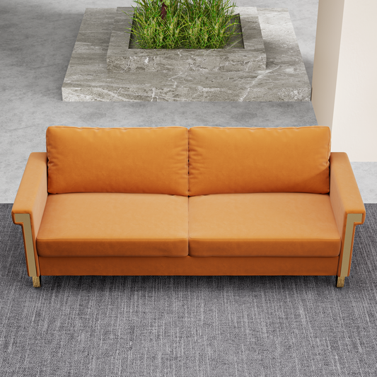 Burnt orange velvet sofa with golden accents on a grey textured rug