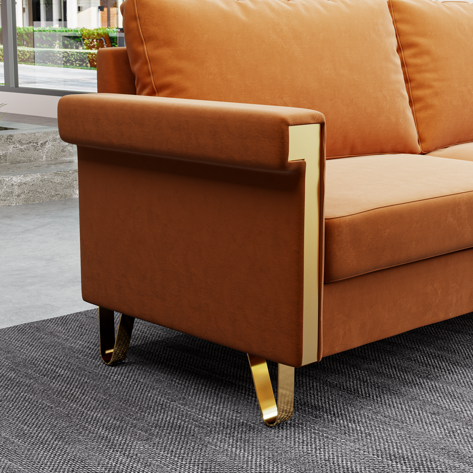 Orange velvet sofa with gold metal accents and plush cushions