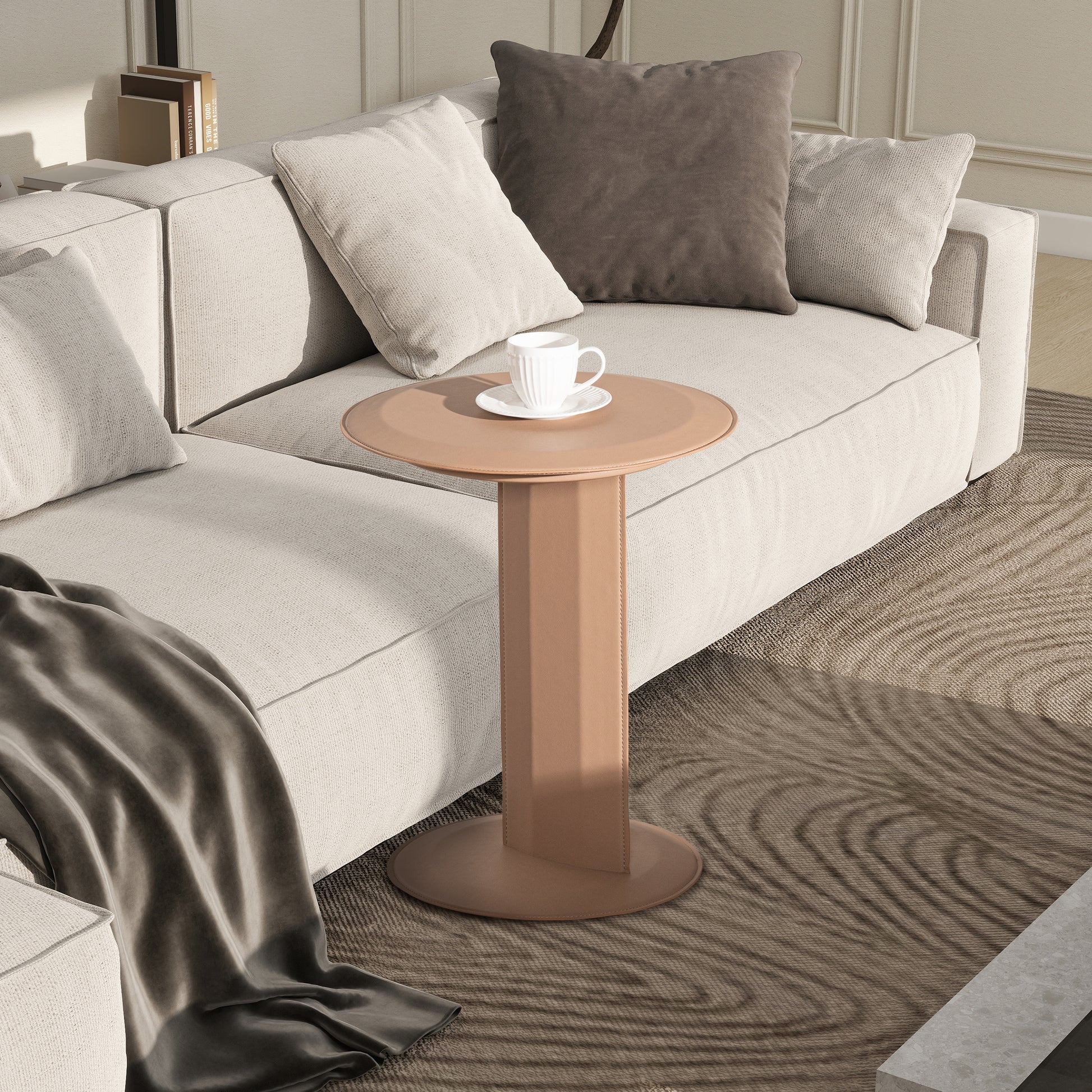 Tan leather accent table with round top beside plush sofa