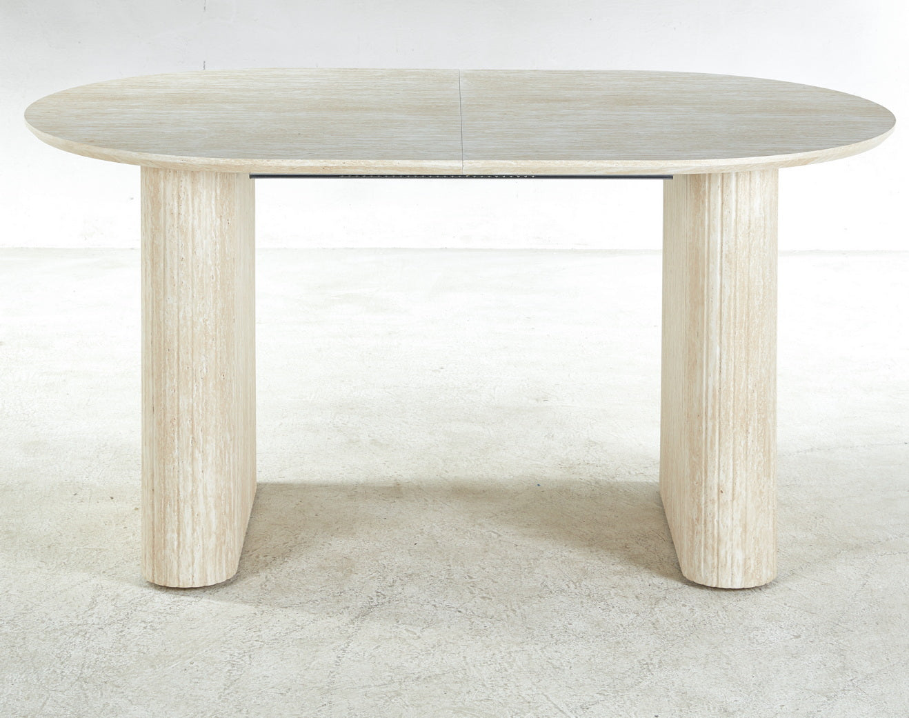 Oval travertine dining table with fluted pedestal legs