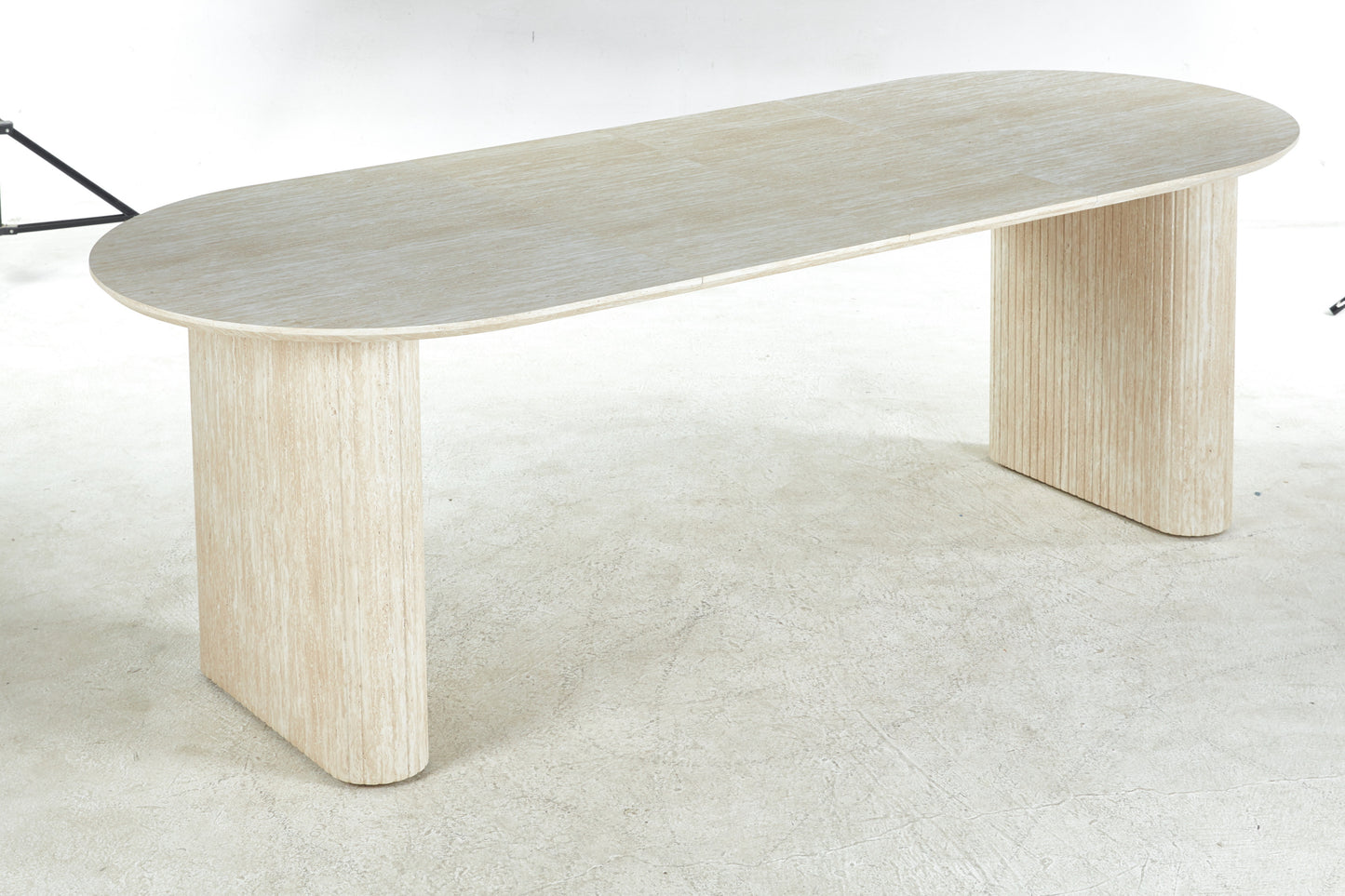 Light travertine oval dining table with fluted pedestal legs