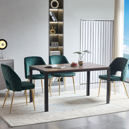 Modern dining set with four emerald green velvet chairs and a woodtop table