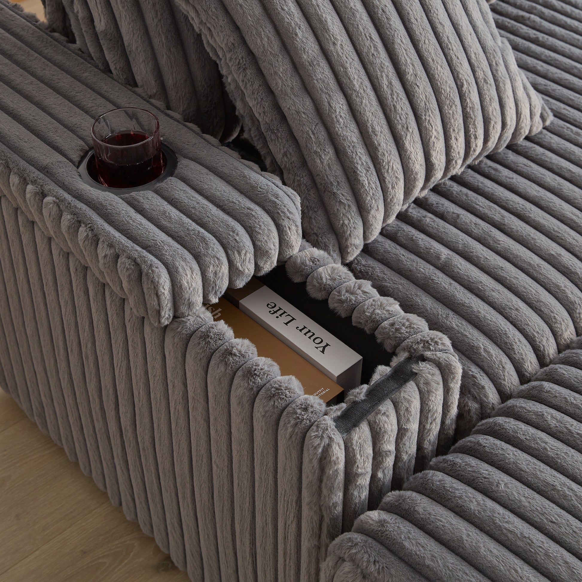 Cozy grey corduroy sofa with builtin storage compartment and drink holder