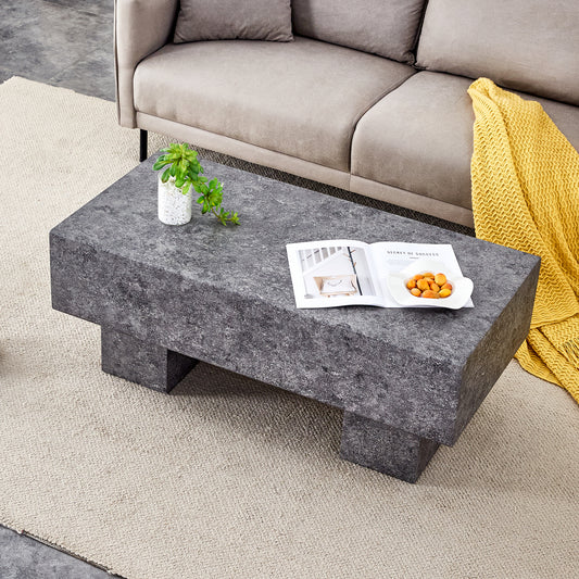 Modern grey stone coffee table with textured finish and geometric legs
