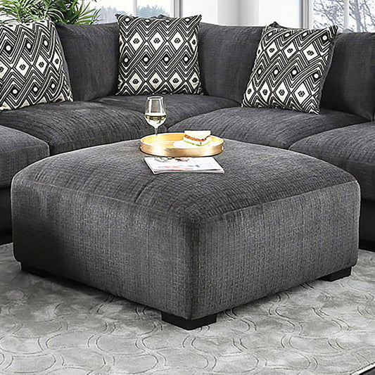 Large charcoal grey fabric ottoman with plush cushioning perfect for a modern living room setup