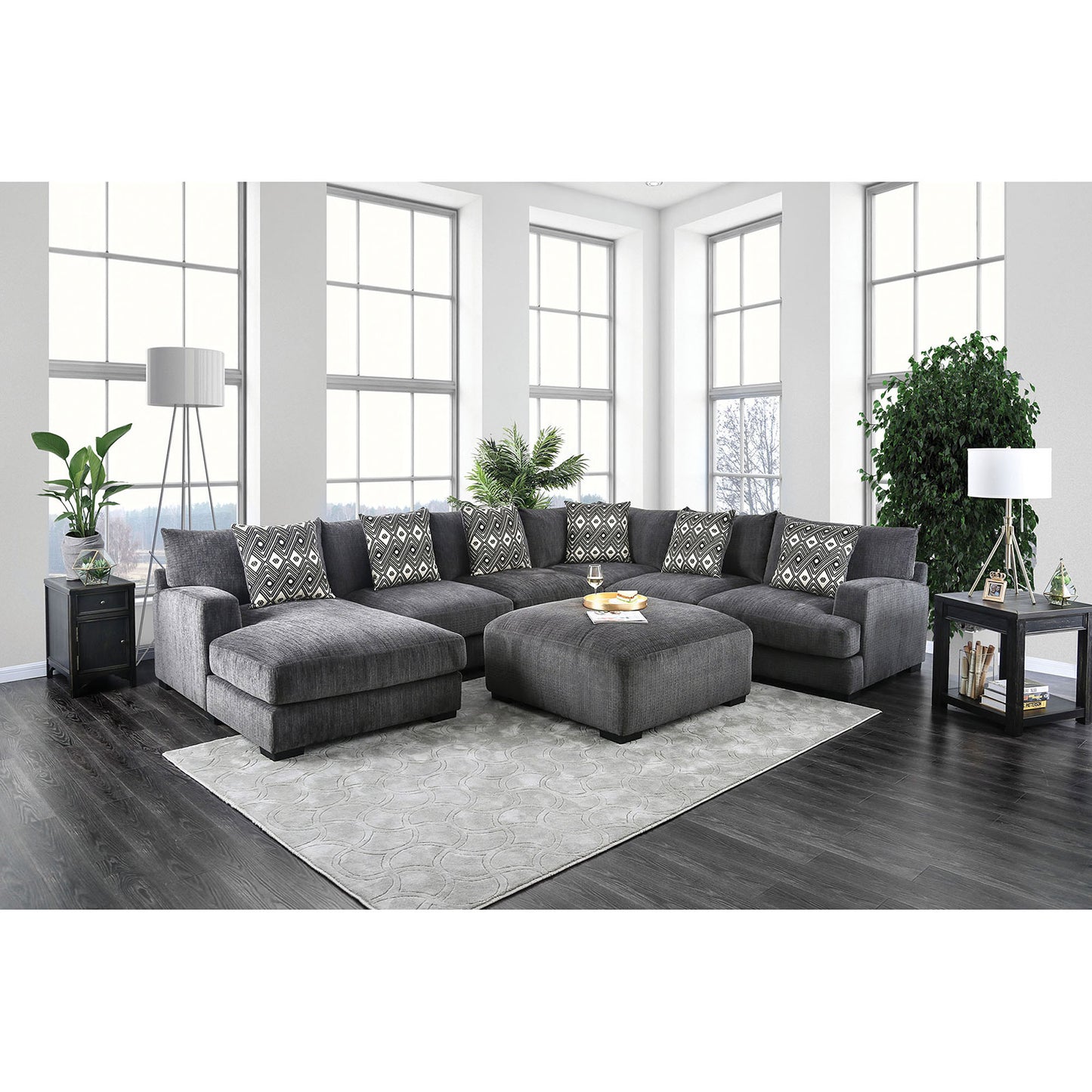 Plush dark gray fabric sectional sofa with patterned throw pillows and matching ottoman