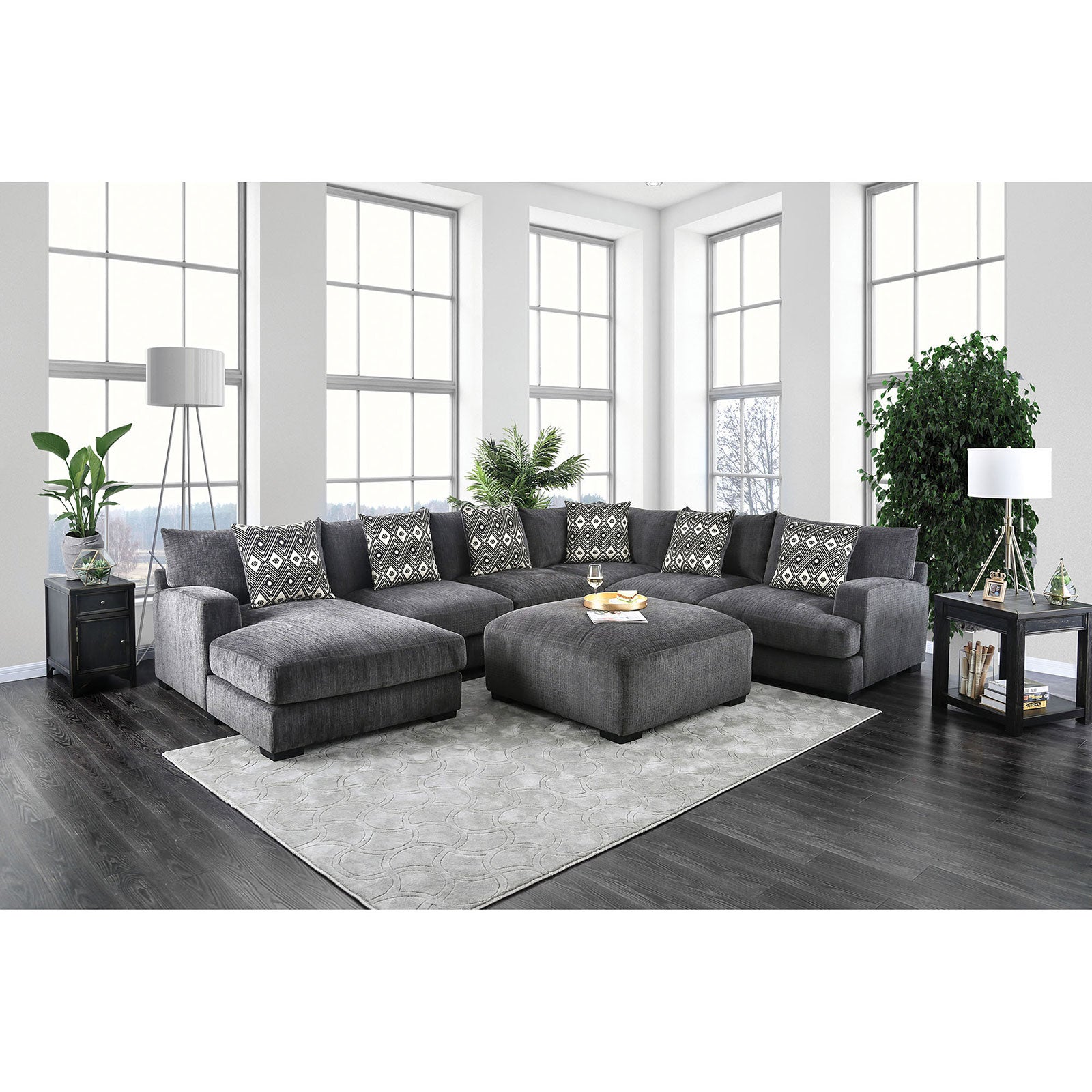 Plush dark gray fabric sectional sofa with patterned throw pillows and matching ottoman