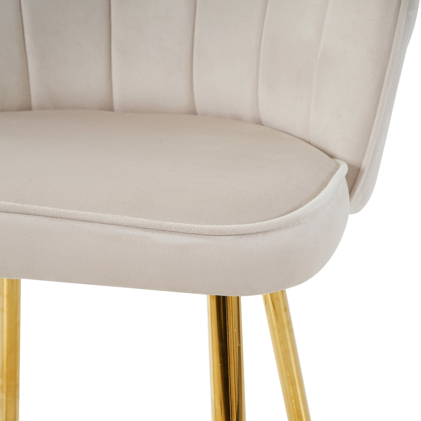 Closeup of a plush cream velvet accent chair with channel tufting and gold legs