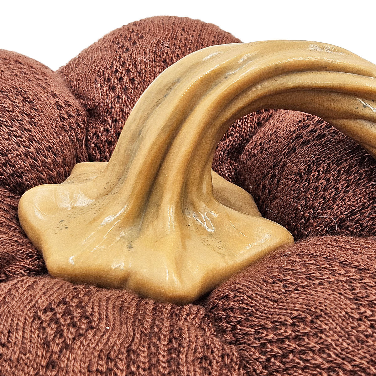 Closeup of a brown knitted fabric with a beige curved stem ideal for fall decor