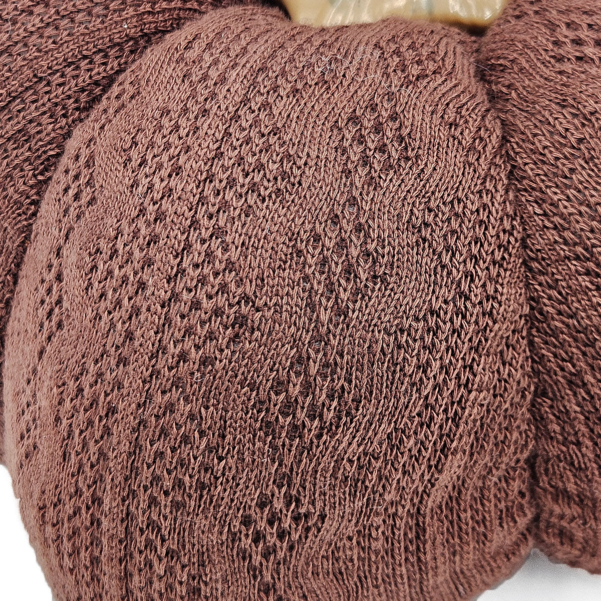 Closeup of a textured brown knit fabric with an openweave pattern ideal for lightweight apparel