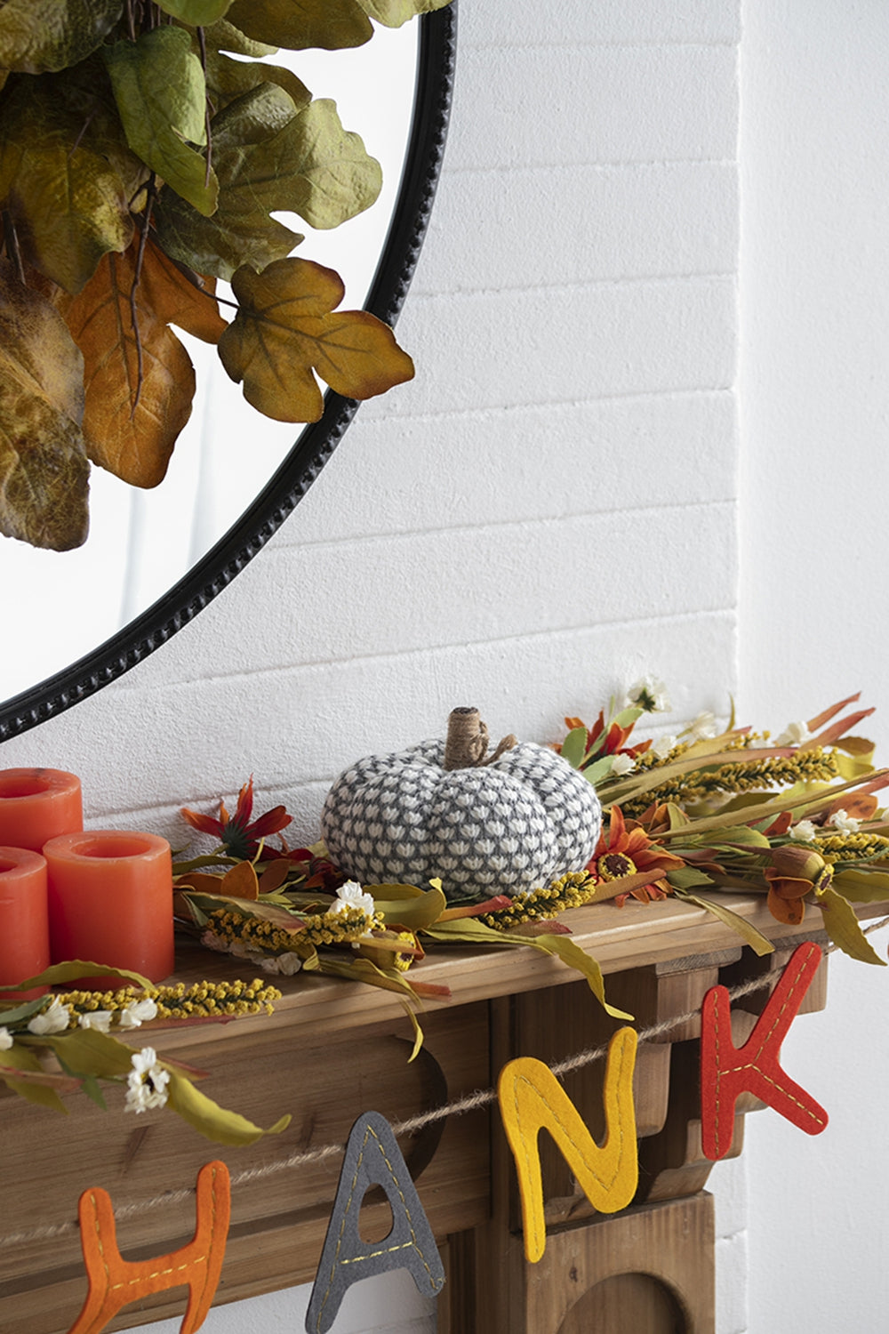 White and grey knitted pumpkin with jute stem on mantle