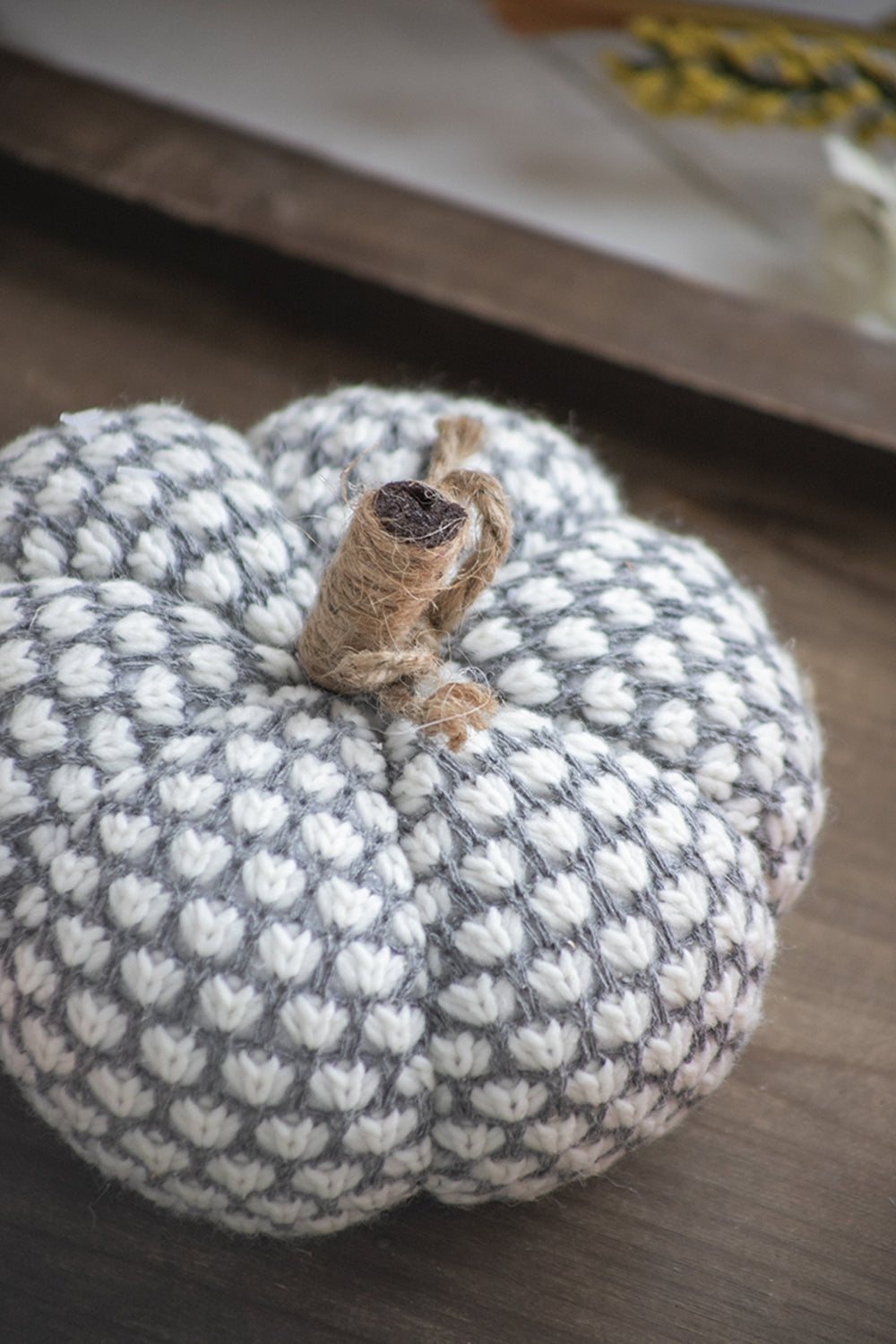 Gray and white knit pumpkin decoration with twine stem