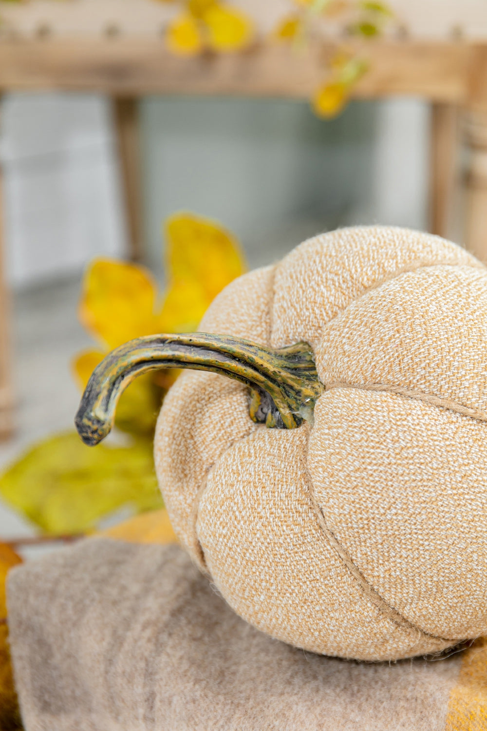 Textured tan fabric pumpkin with a realistic green stem and jute twine detail