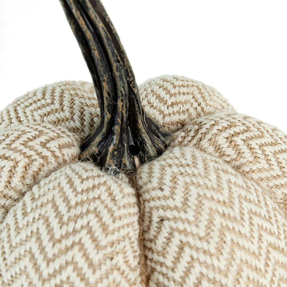 Closeup of a beige chevron textured fabric pumpkin with a dark brown realistic stem