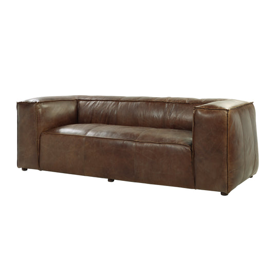 A rich brown leather sofa with tufted seat and arms perfect for a living room