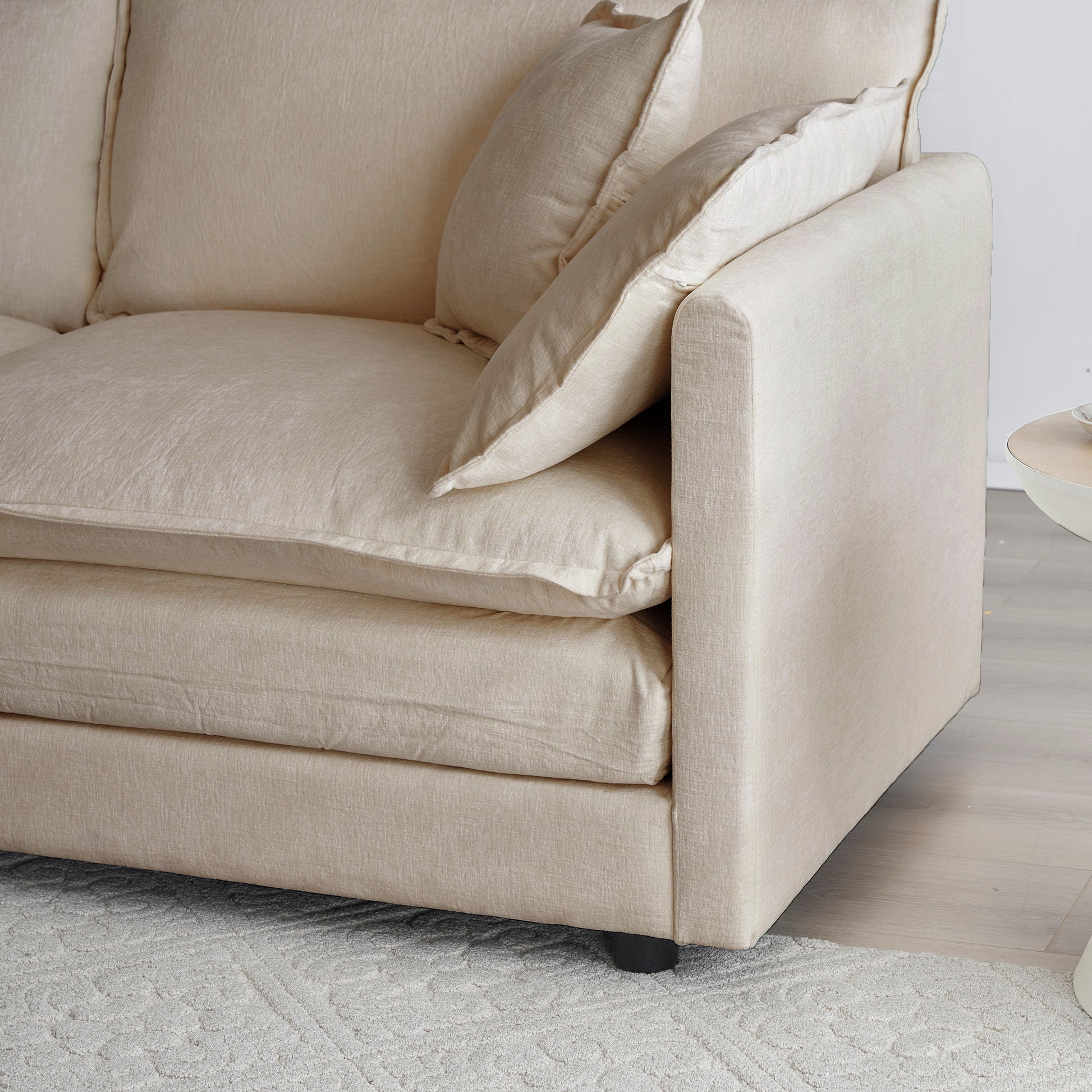 Comfortable cream linen sofa with plush seat cushions and accent pillows