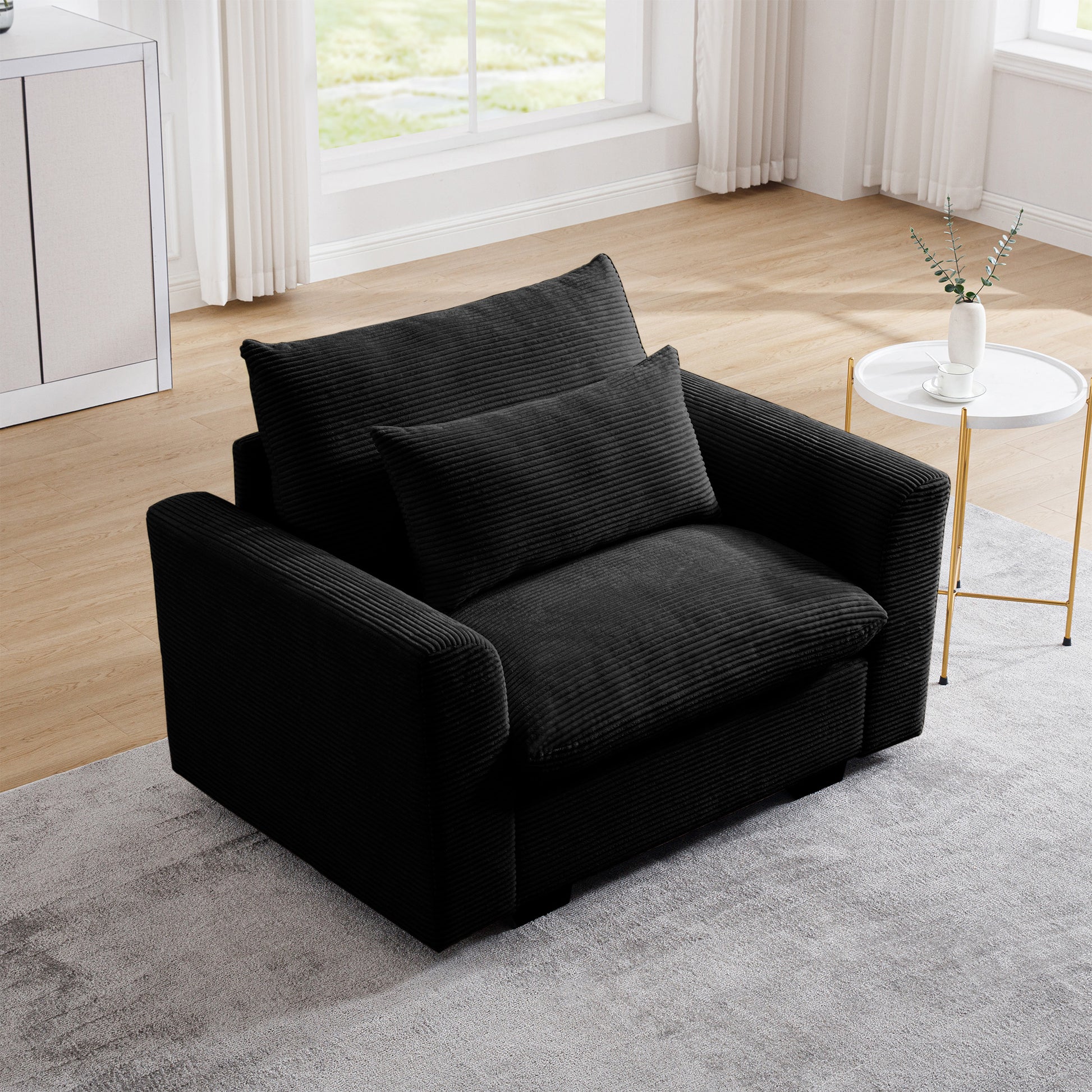 Plush black corduroy accent chair with matching throw pillow ideal for a cozy living room