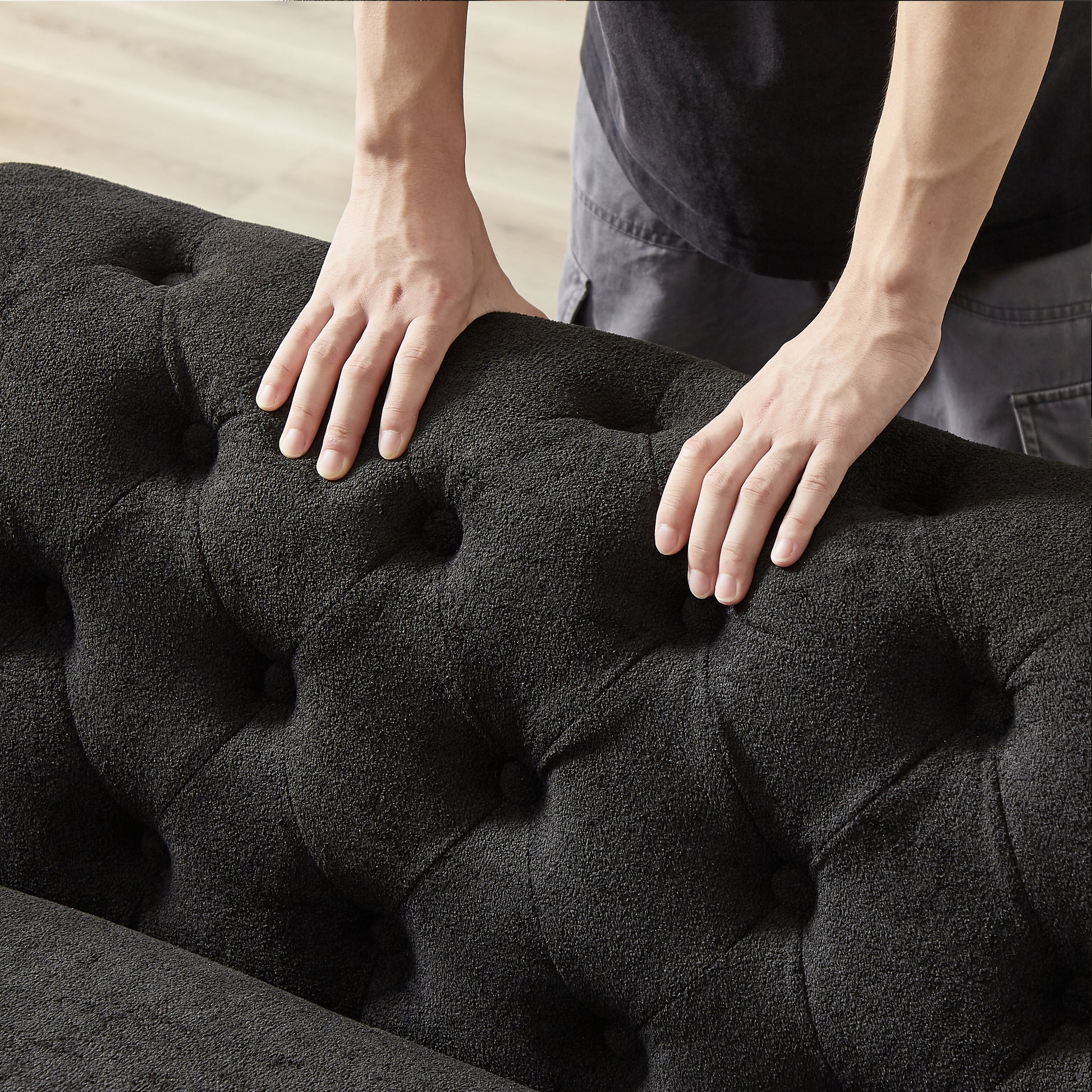 Black textured fabric sofa with tufted buttons showcasing plush upholstery