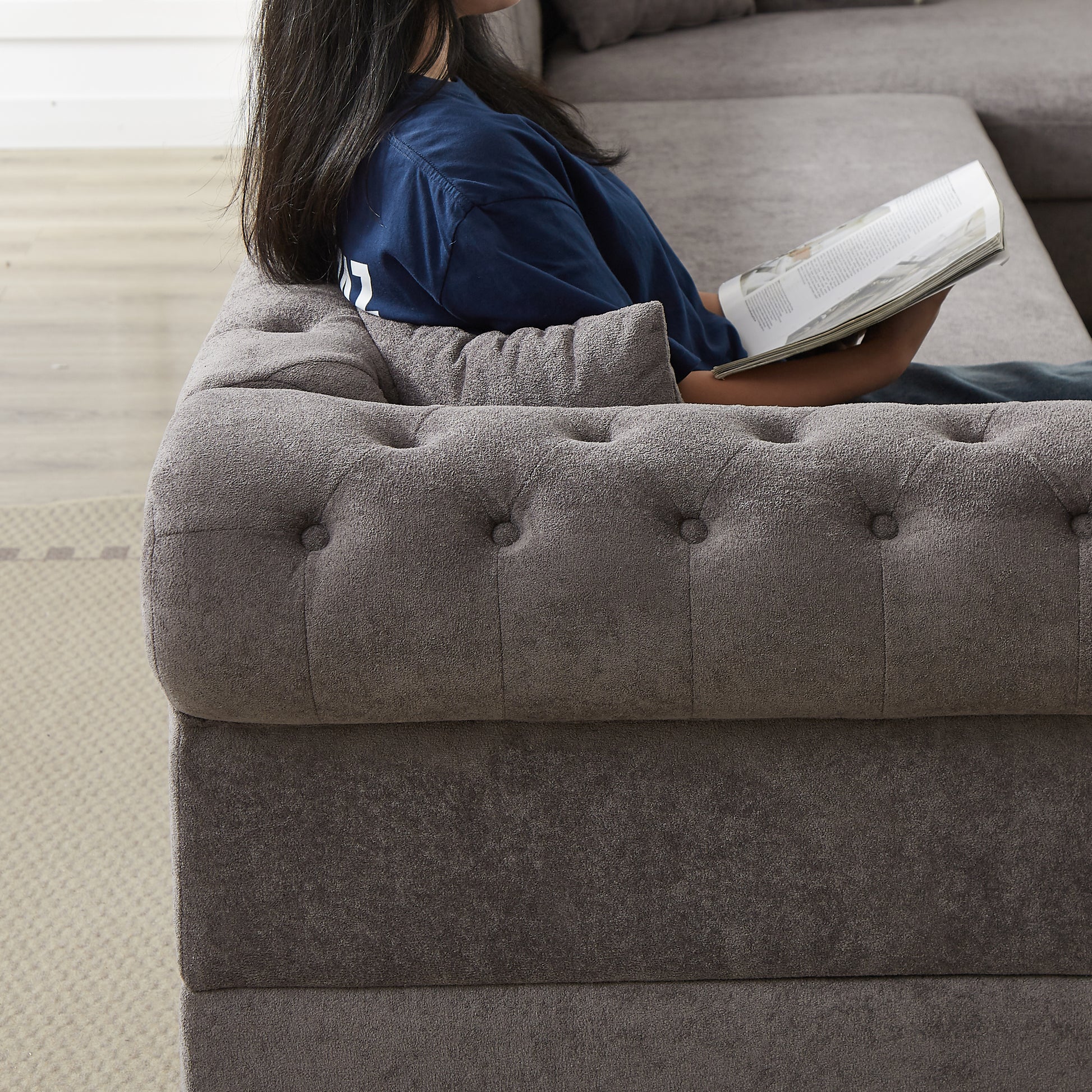 Gray tufted fabric sofa armrest with button details for living room comfort
