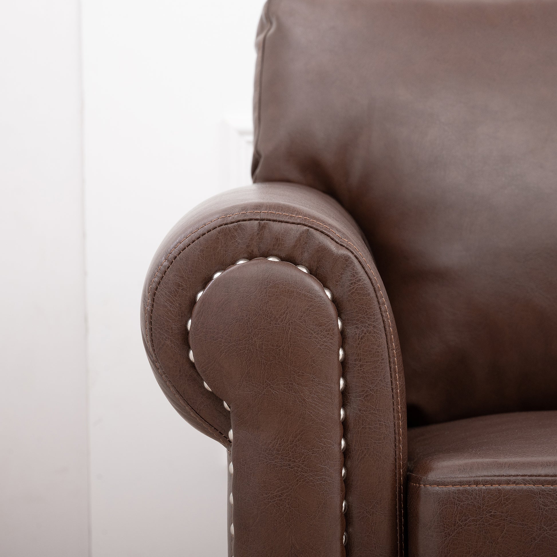 Brown faux leather accent chair with nailhead trim detail