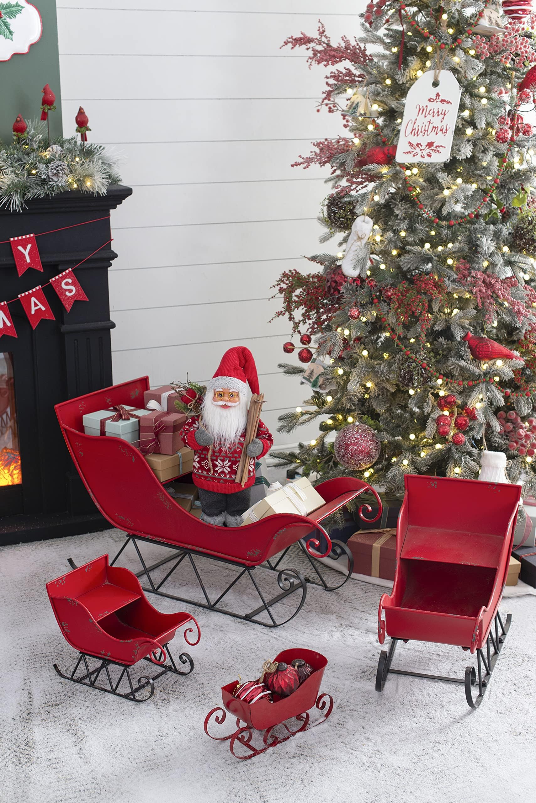 Red metal Christmas sleigh with gifts and Santa figurine
