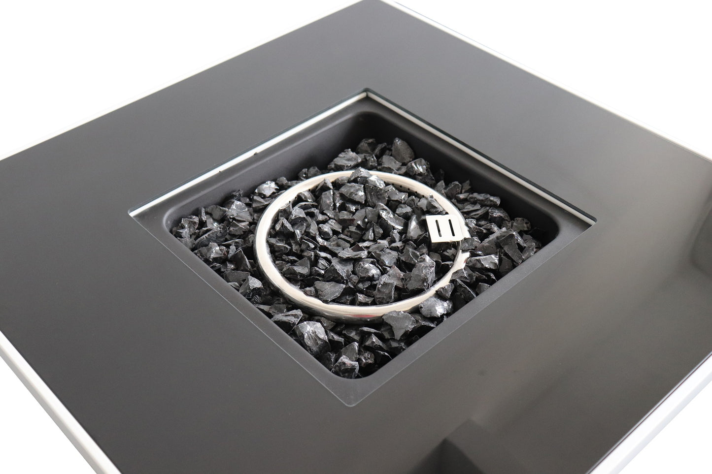 Closeup of a sleek modern propane fire pit with a black glass bed and silver burner ring