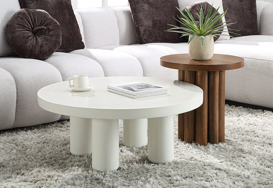 White round coffee table with thick legs and a book perfect for living rooms
