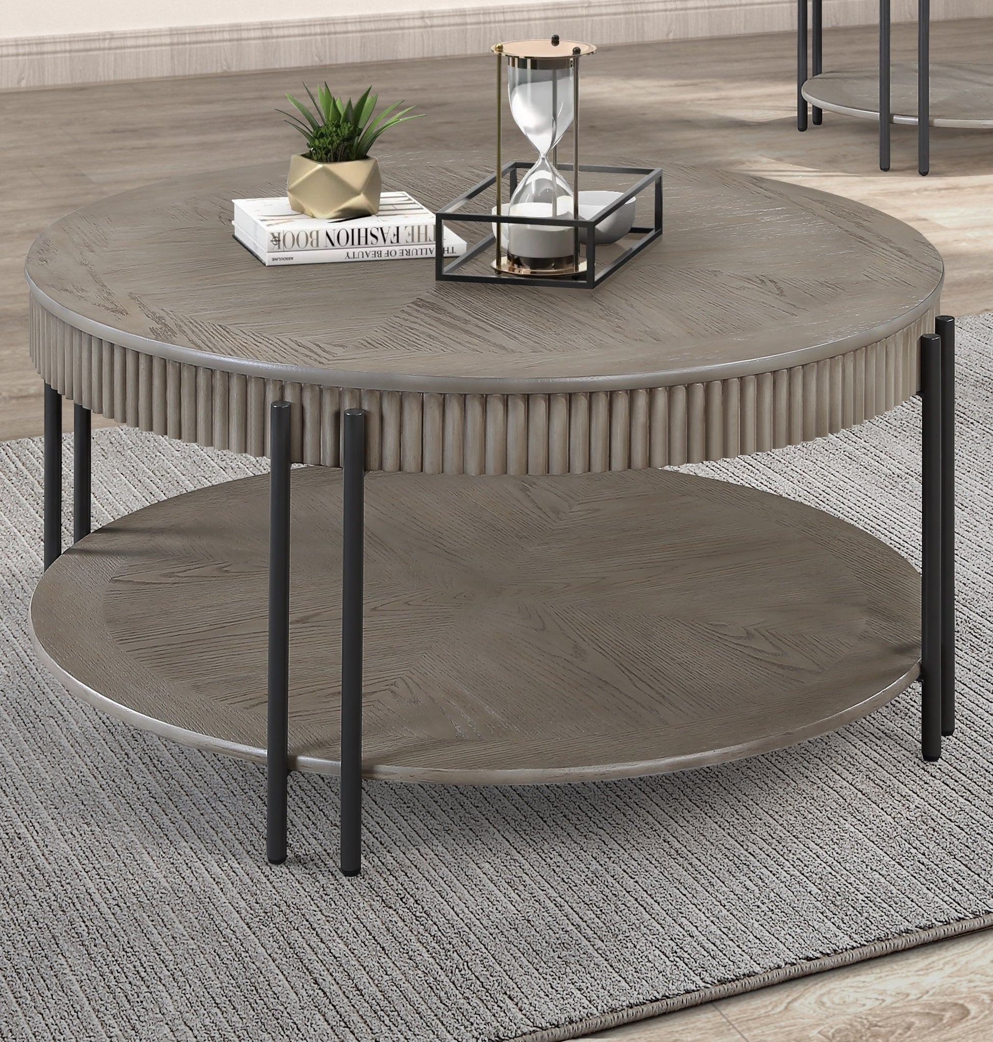 Round wooden coffee table with fluted sides and two tiers featuring dark metal legs and a herringbone top