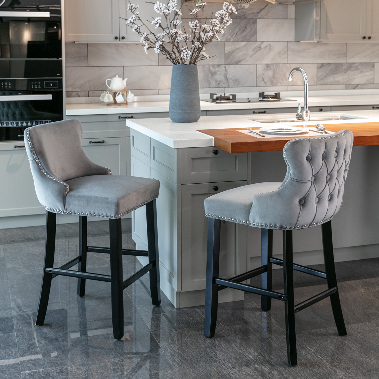 Grey velvet tufted bar stool with silver nailhead trim and black legs