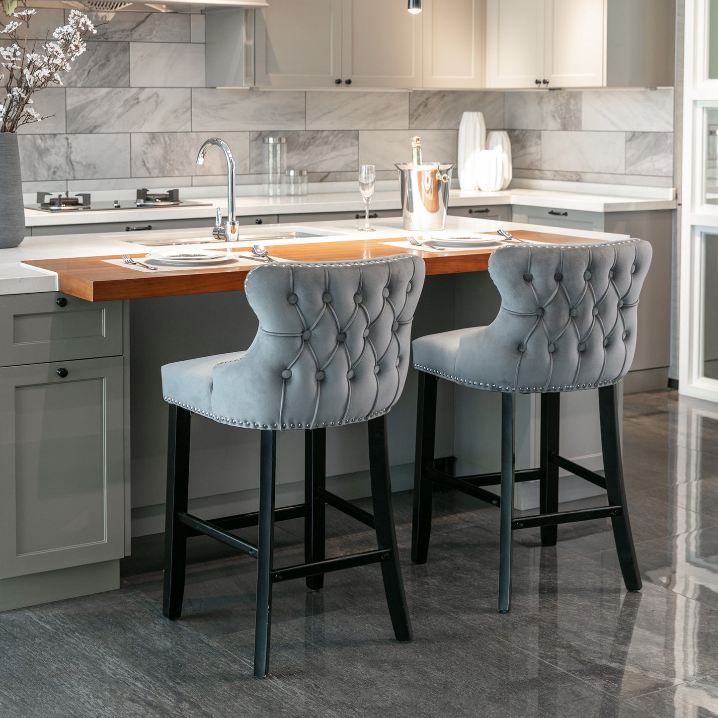 Grey velvet tufted bar stool with silver nailhead trim and dark wood legs