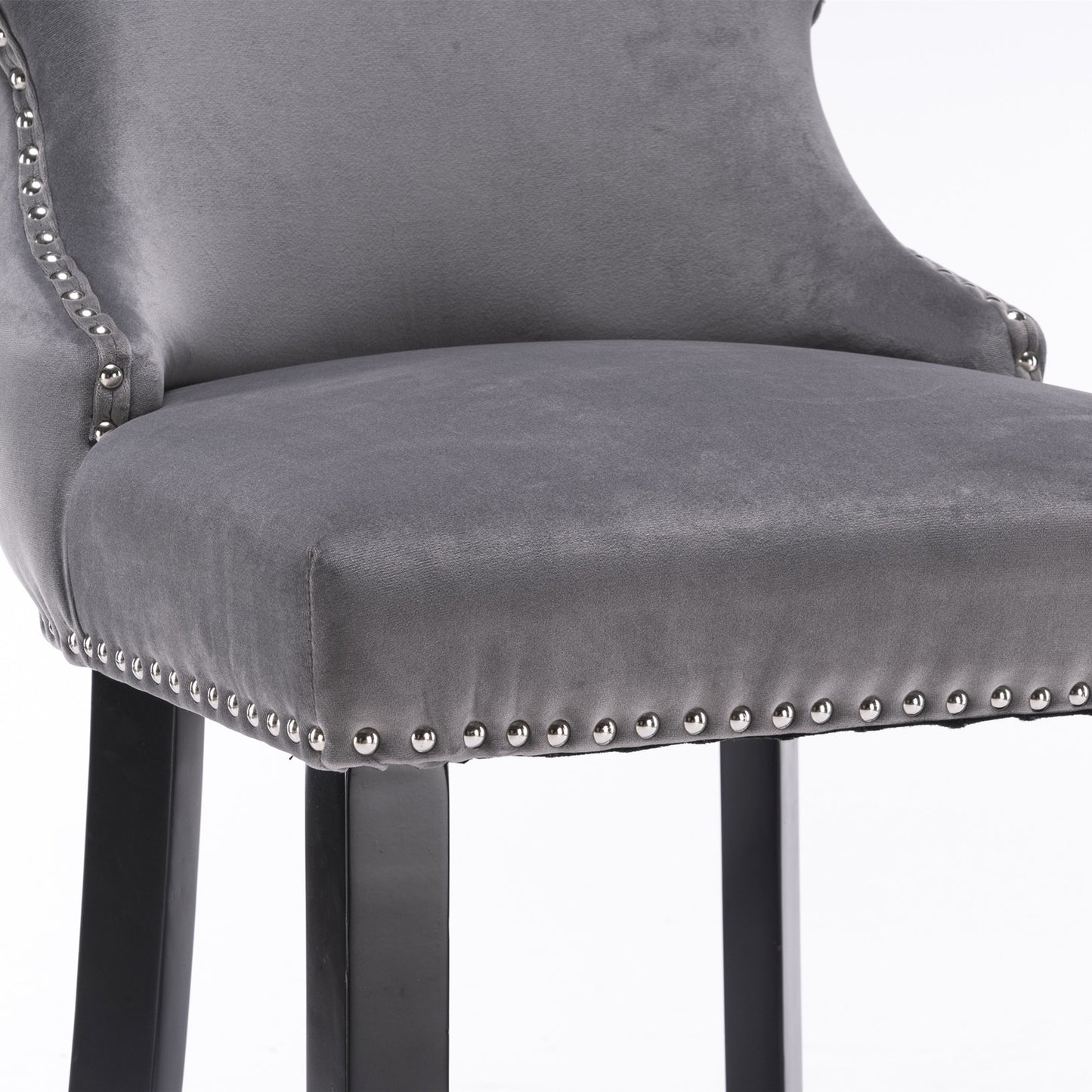 Closeup of grey velvet bar stool with silver nailhead trim and black legs
